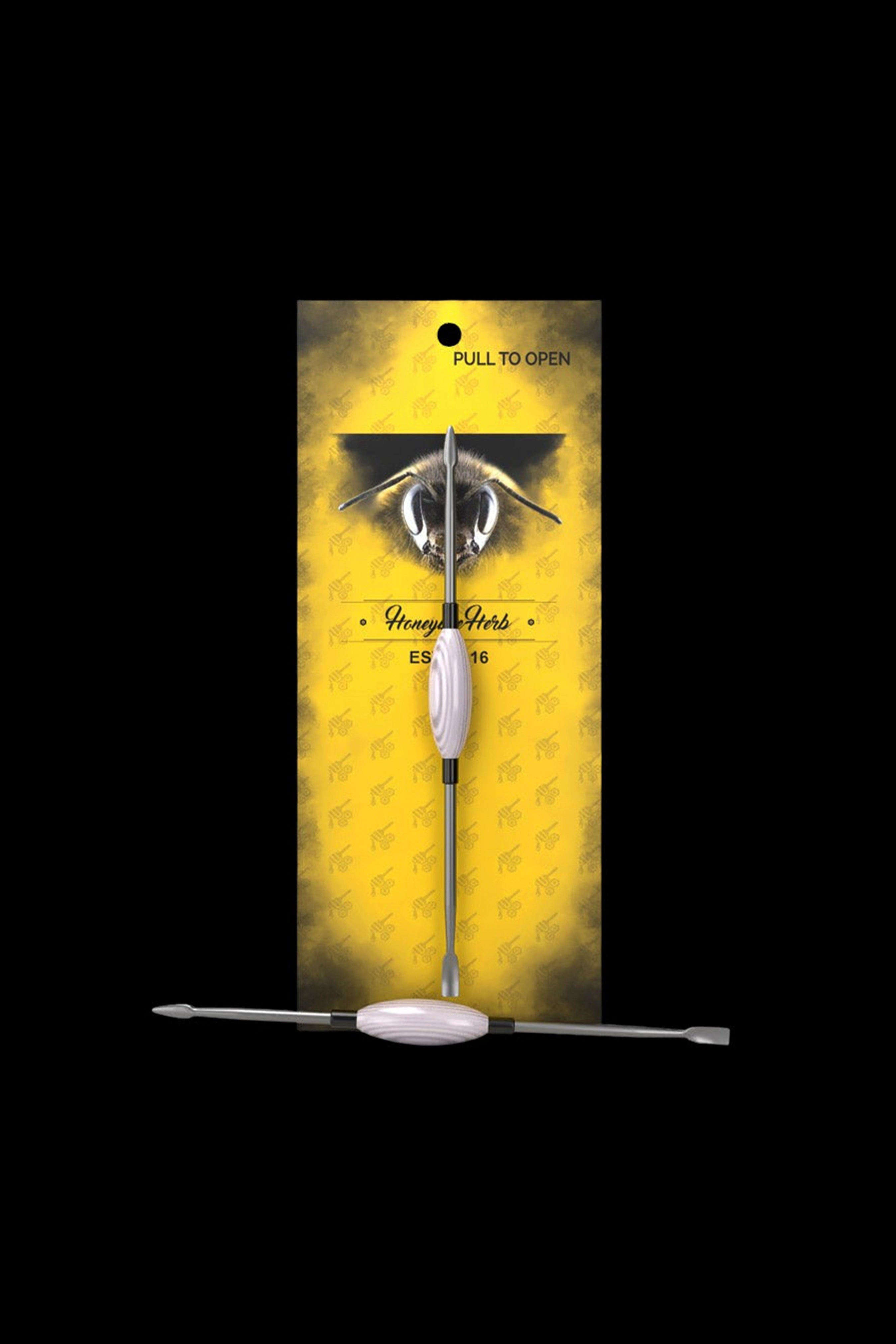 A vertical, rectangular cannabis packaging box with a bee illustration and the brand name ""Honeye Herbs"" displaying a metallic dab tool inside."