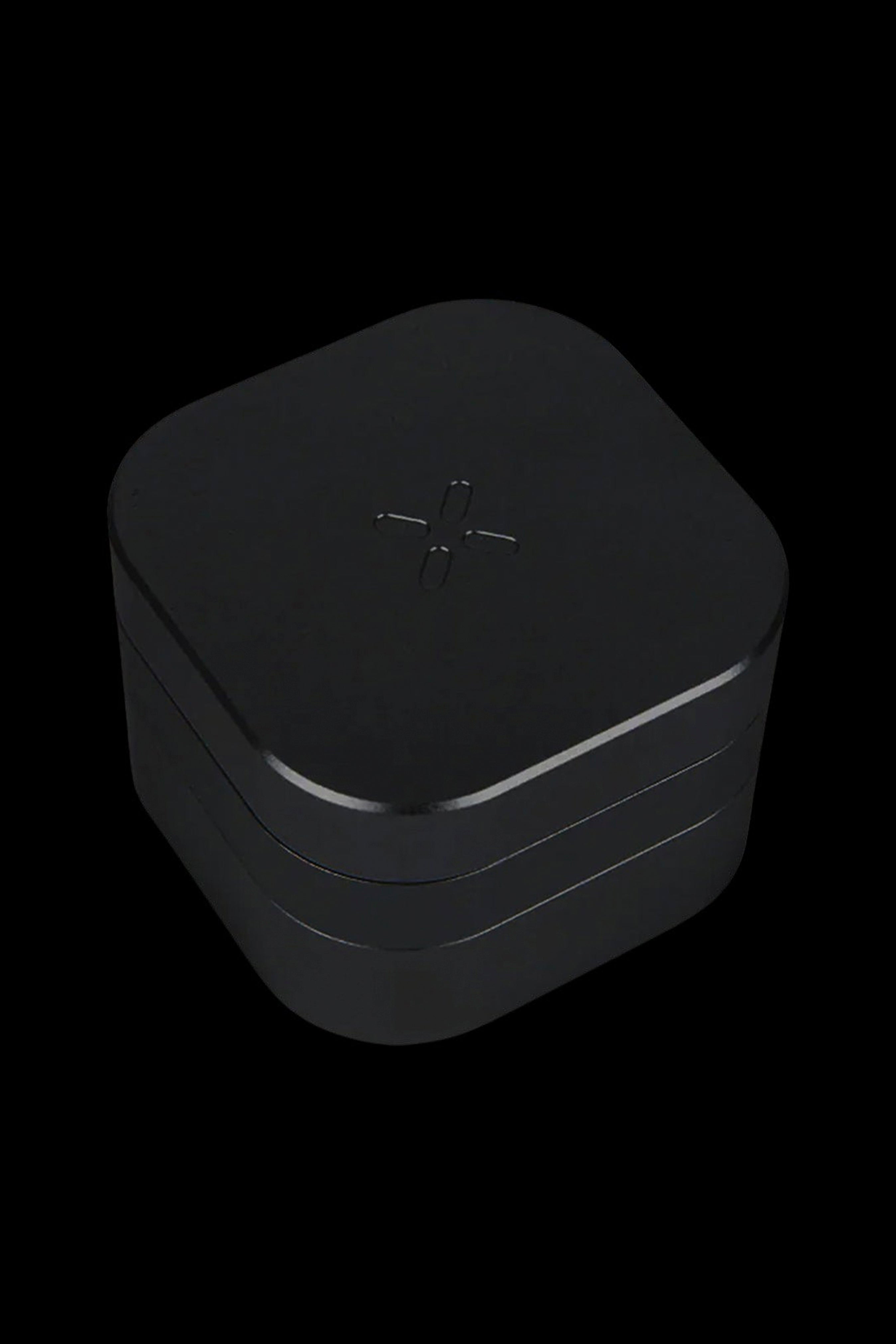 Black cannabis storage container with a stylized cross symbol.