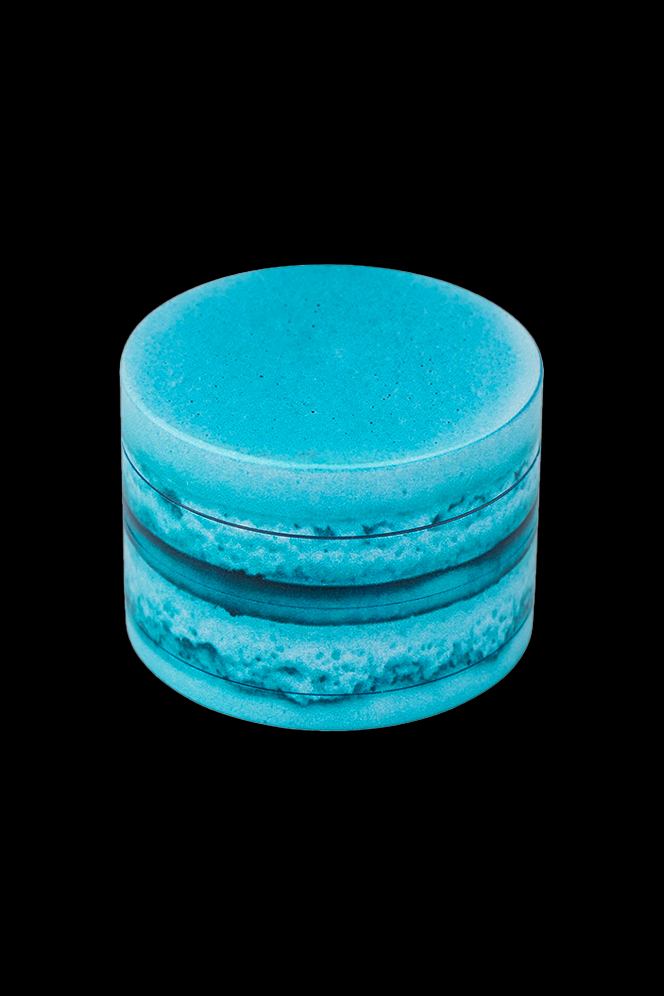 Blue cannabis grinder isolated on a black background.