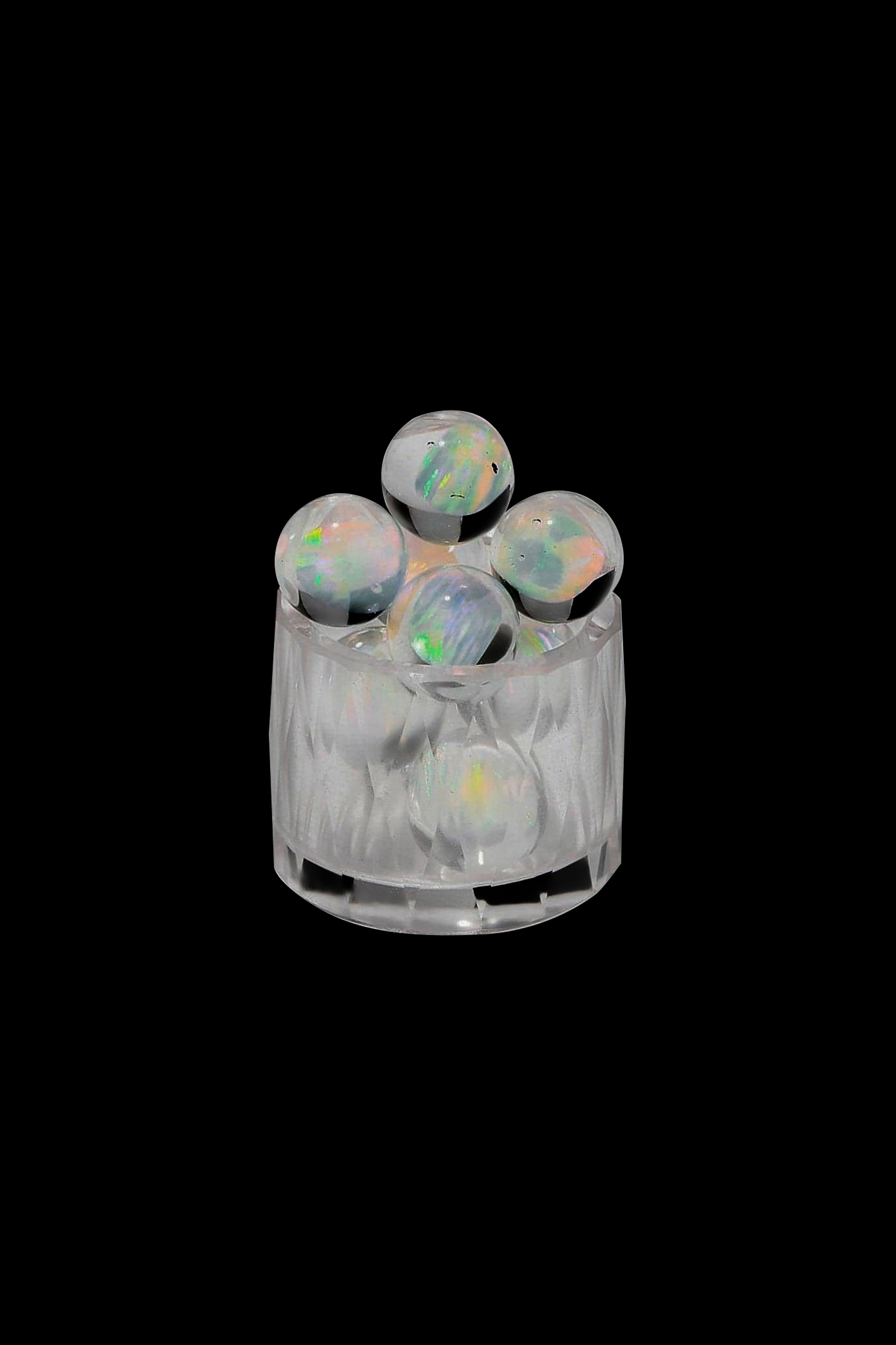 Iridescent cannabis concentrate pearls inside a clear container.