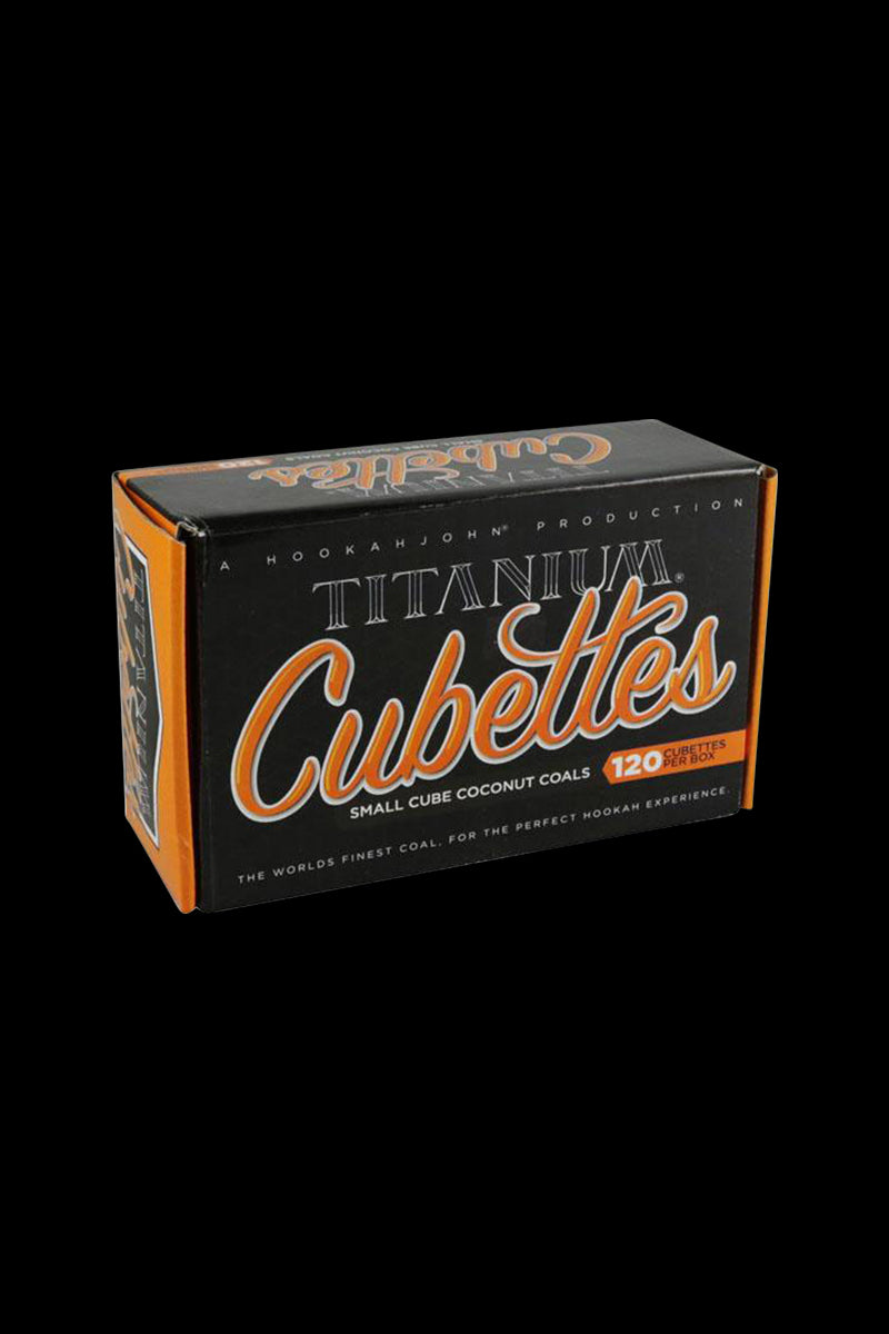 A close-up of the 120 Titanium Coconut Coals - CUBETTES packaging, showing the branded box in a brightly lit studio setting.