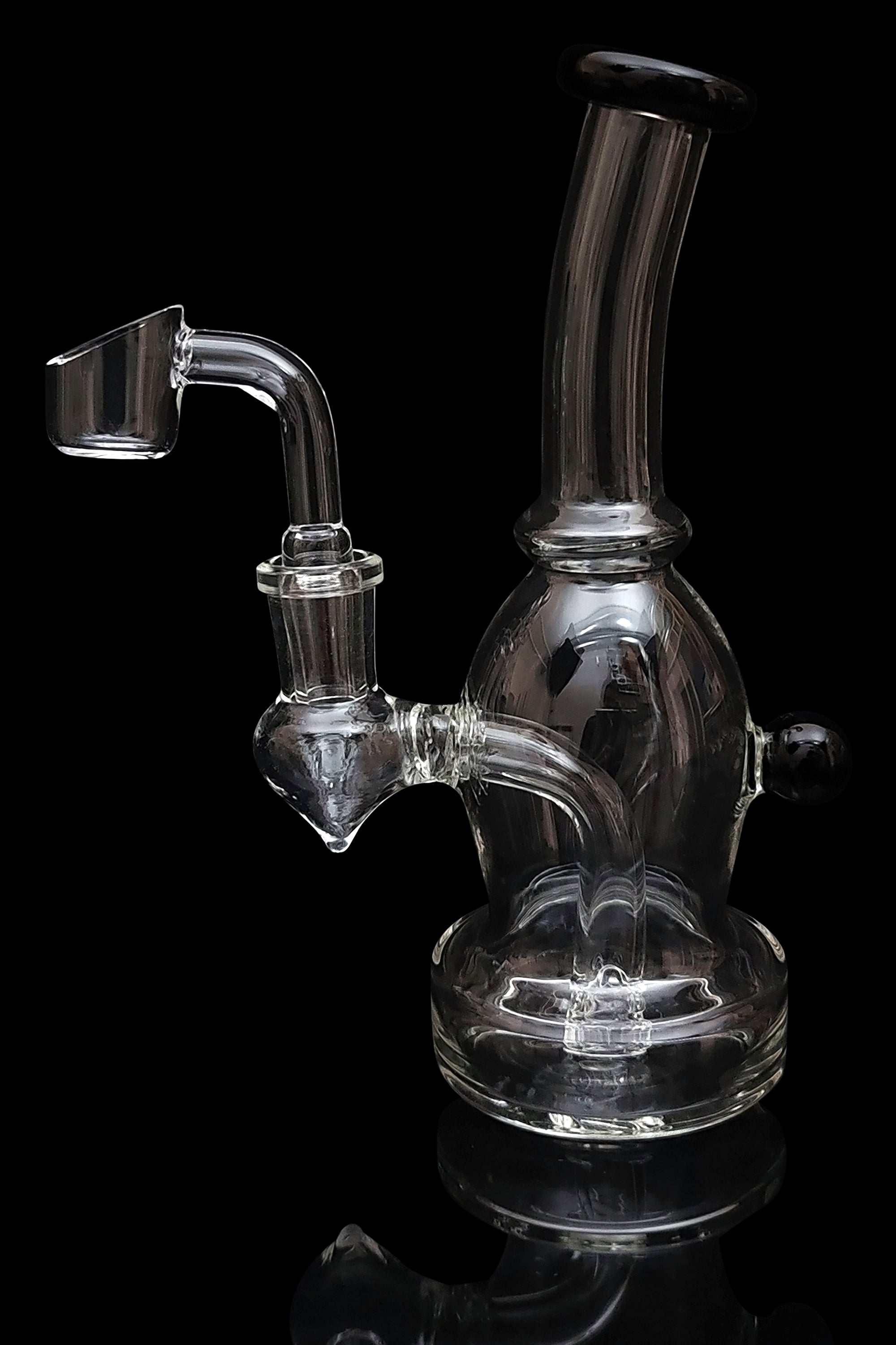 Clear glass dab rig with a quartz banger, isolated on a black background.