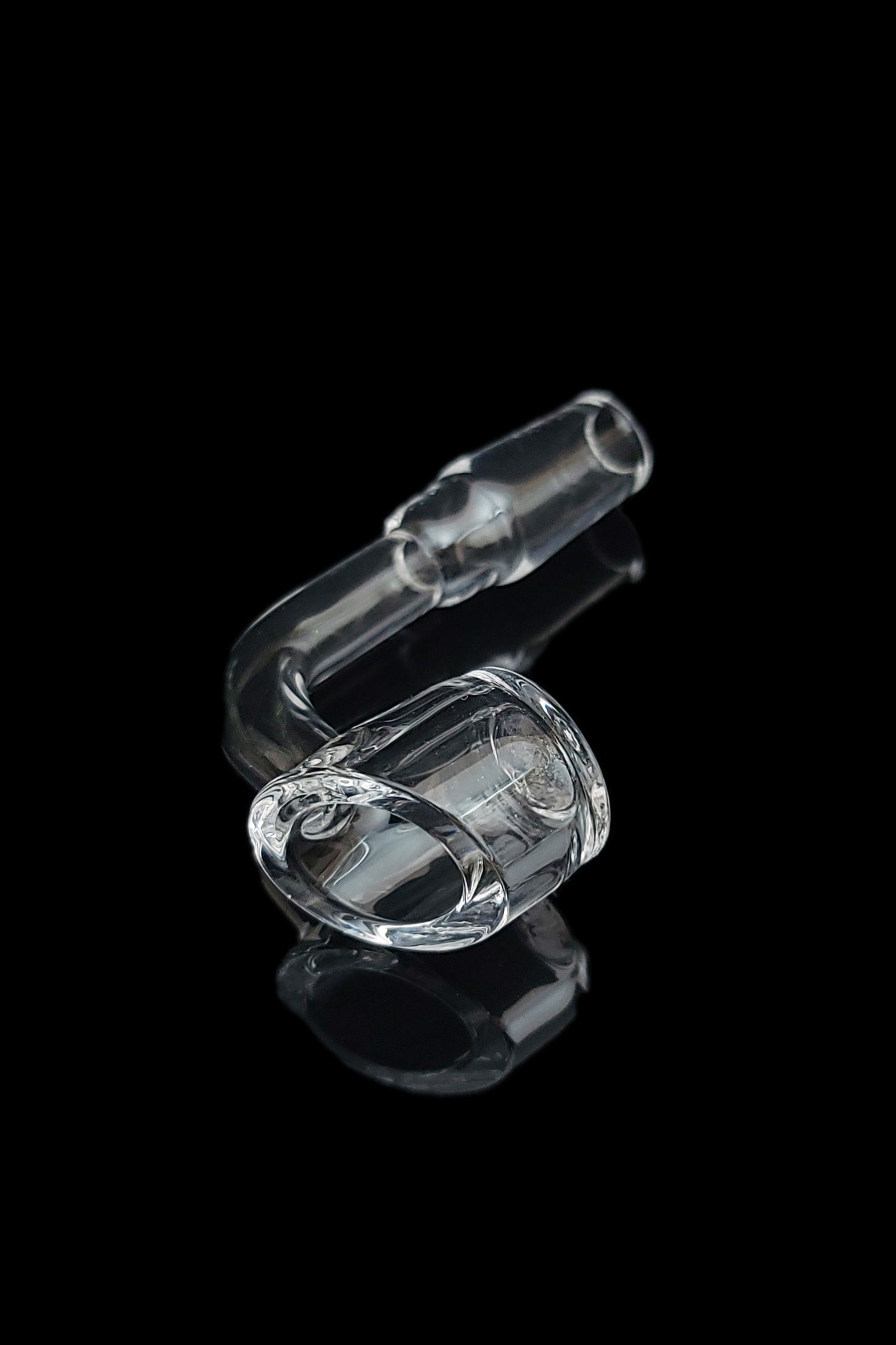Clear glass oil rig with a rounded chamber, reflecting on a dark surface.