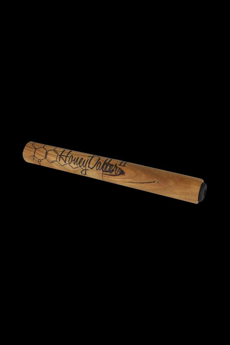 Angled close-up of a wooden Honey Dabber II Vapor Straw Collector resting on a black background, showing engraved logo and hexagon pattern.