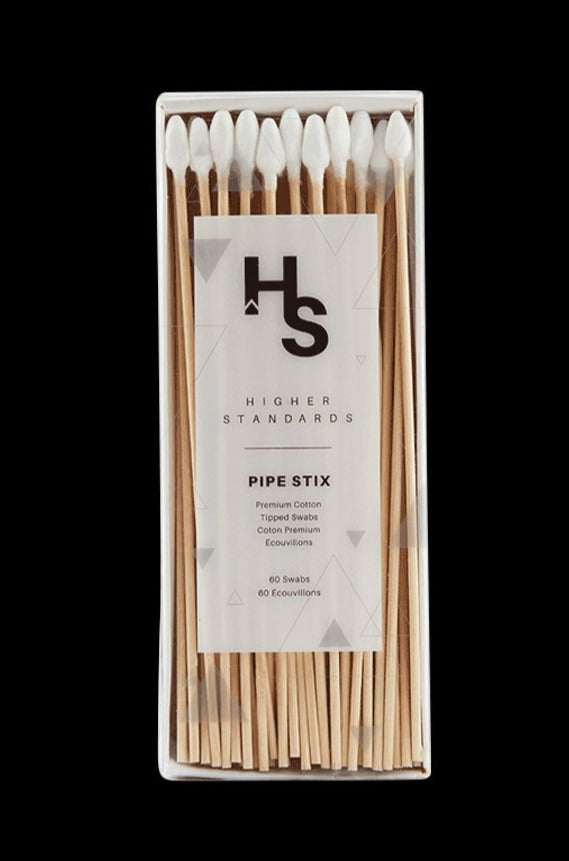 Top-down view of a clear box of Higher Standards Pipe Stix showing white cotton-tipped wooden swabs neatly aligned against a black background
