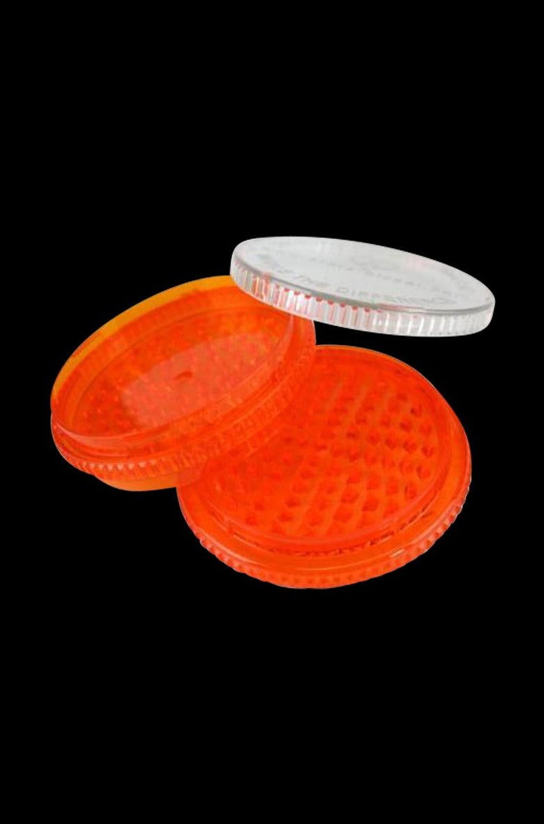 Angled close-up of a translucent orange 3-piece grinder with a clear lid, the Storz & Bickel Volcano Herb Mill XL Acrylic Grinder displayed on black.