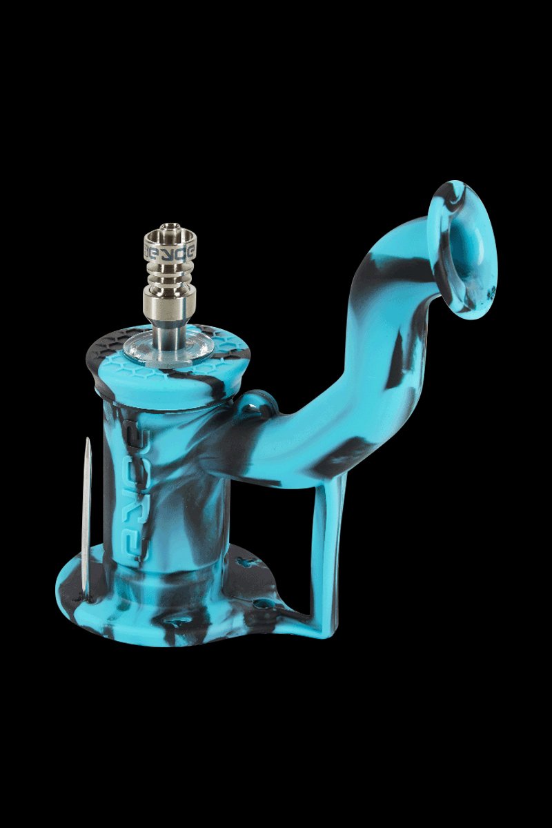 Angled studio shot of a magenta-tinted blue silicone piece with black swirls, the EYCE Rig II Silicone Bong shown against a black background.