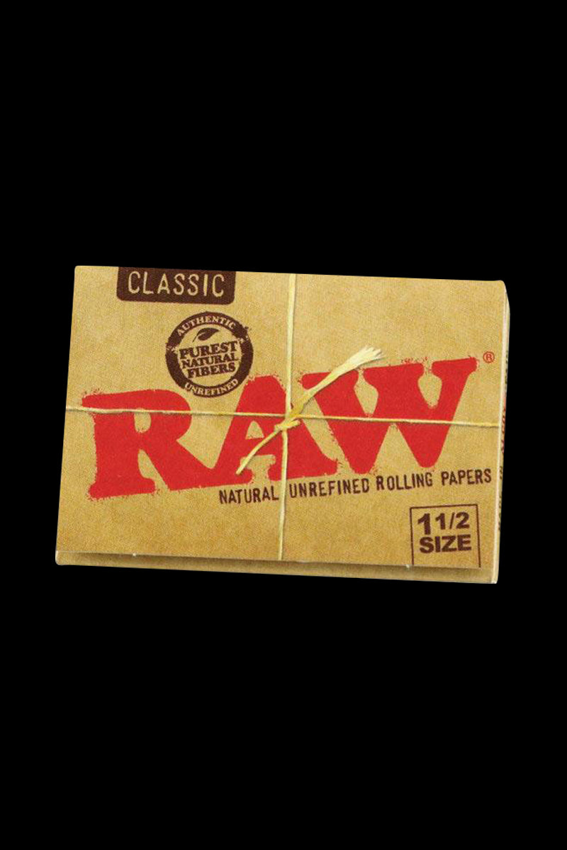 A close-up, angled shot of the RAW Classic 1 1/2" Rolling Papers package against a dark background, highlighting the brand lettering.
