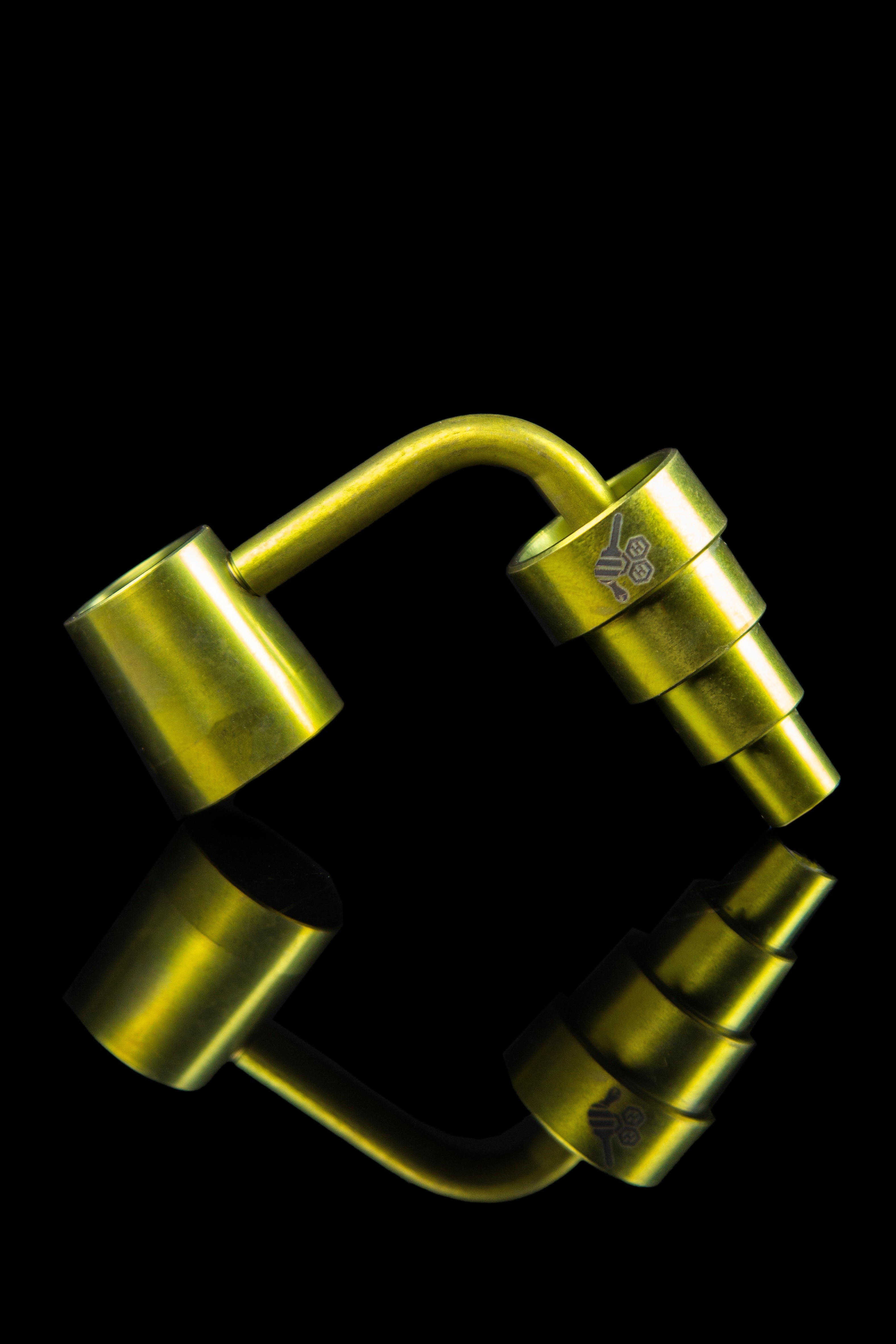 Gold cannabis dab rig with mirrored reflection.