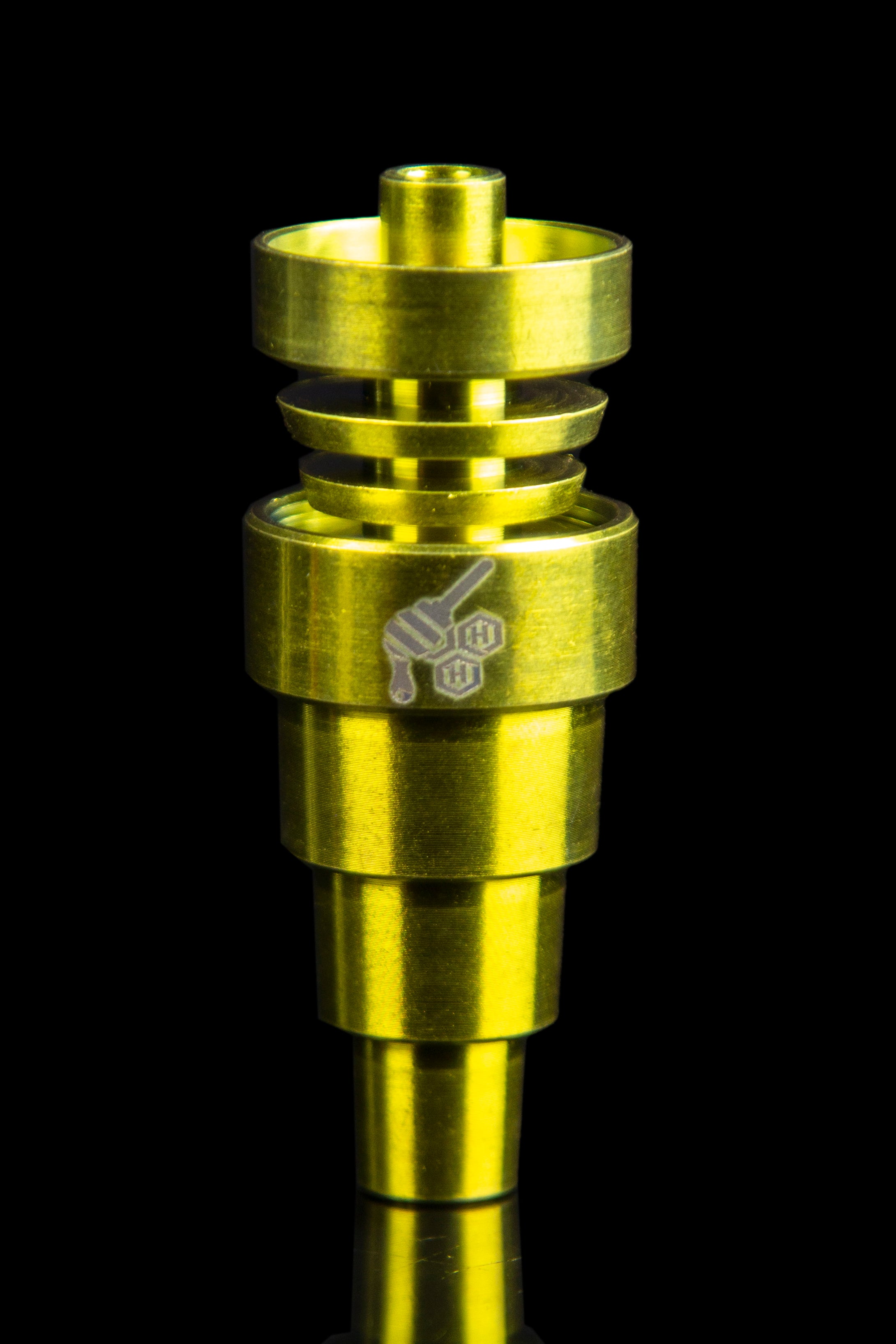 Gold-colored dab rig with etched design against a black background.