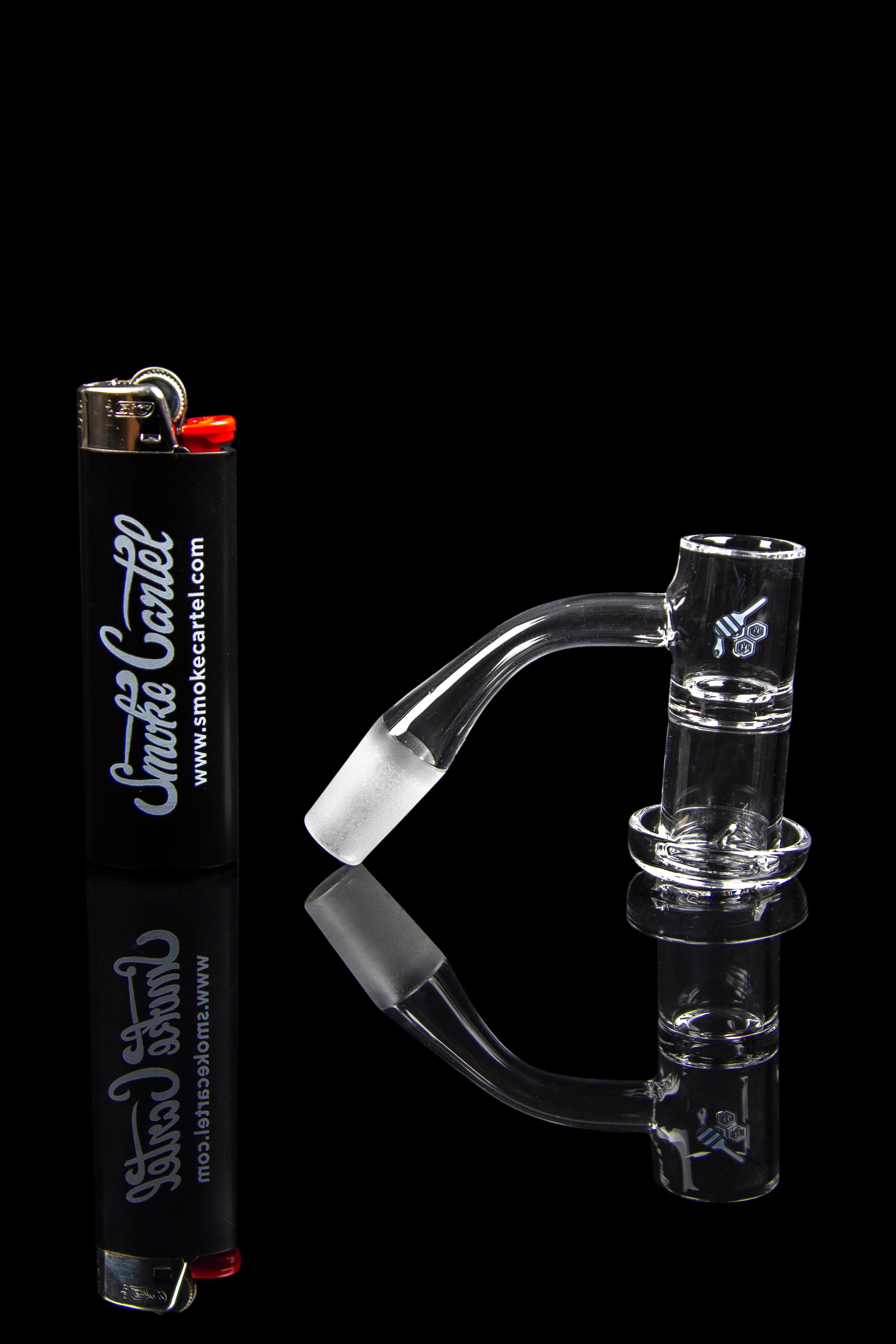 Clear glass water pipe and accessories with a lighter, isolated on a black background.