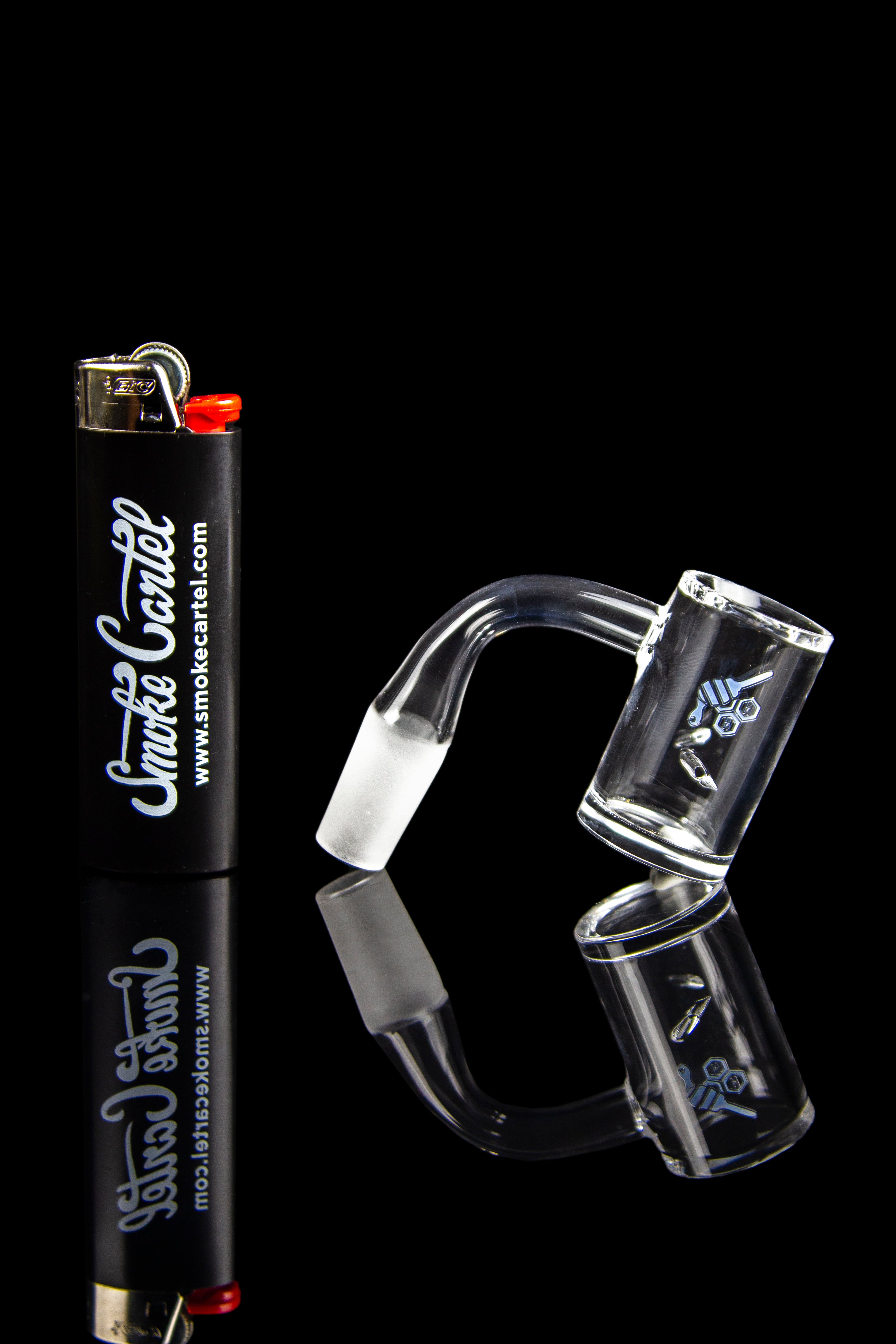Glass dab rig and lighter against a black background.