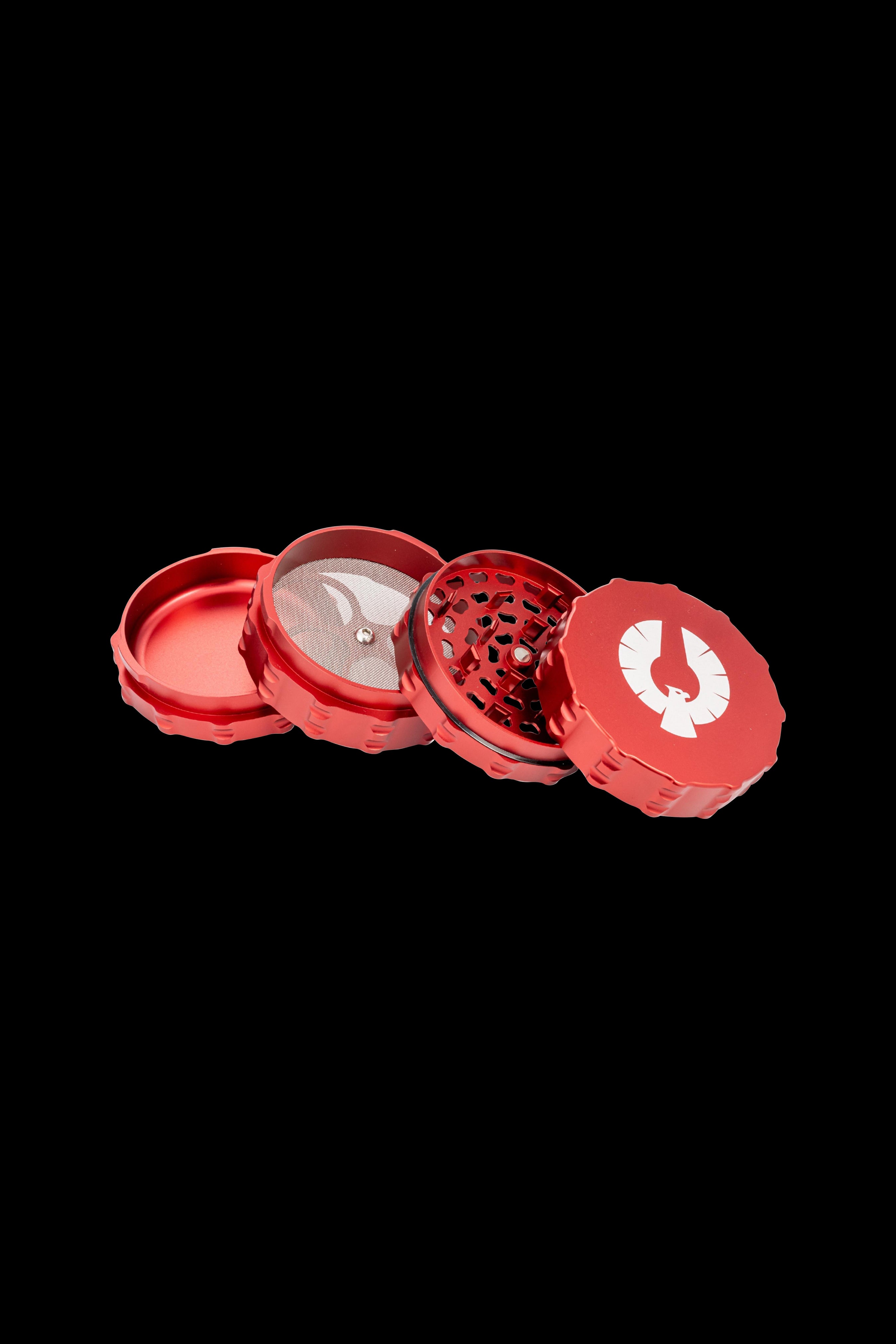 Red four-piece cannabis grinder with a winged design, disassembled to show internal components.