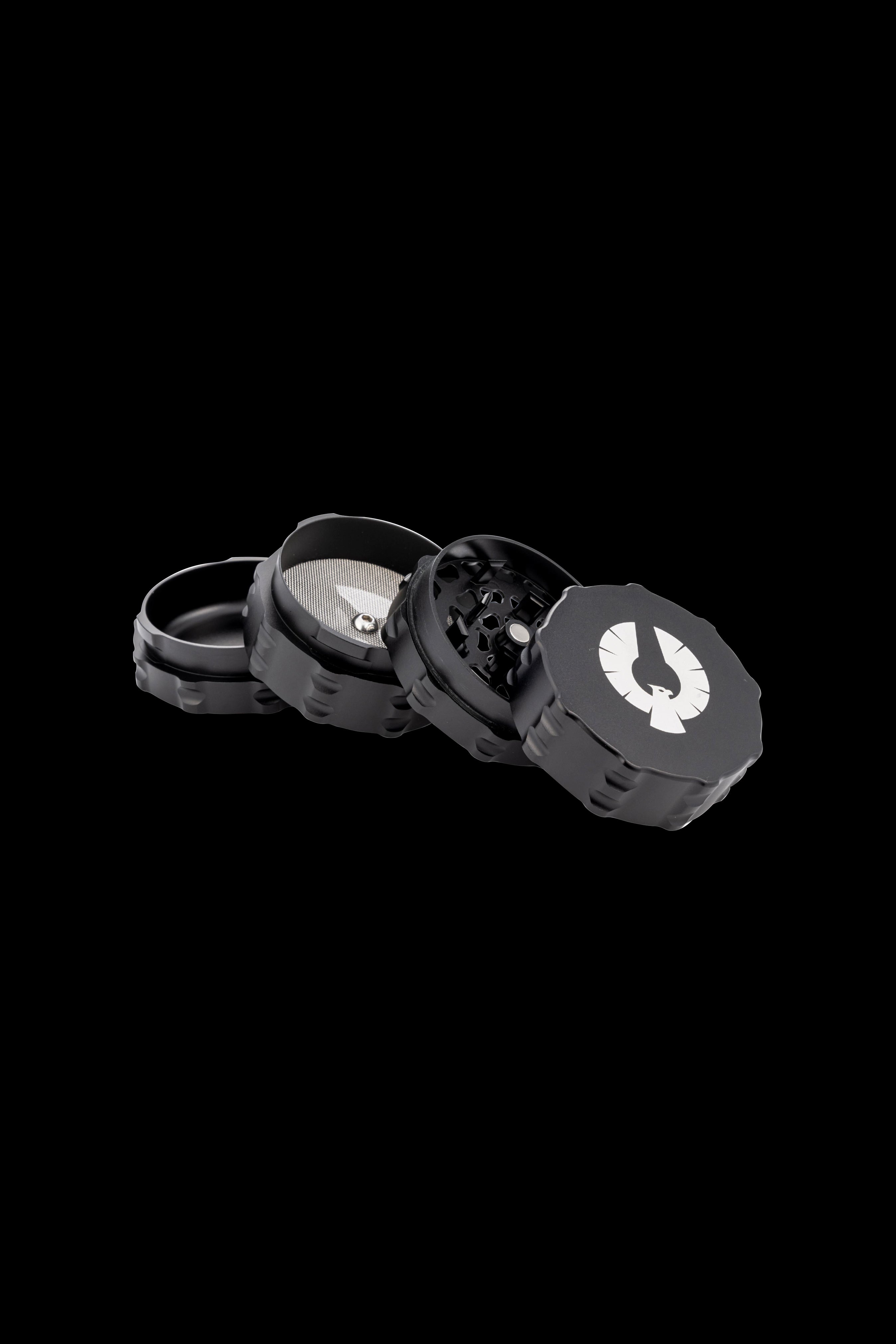 Black four-piece cannabis grinder with a white logo.