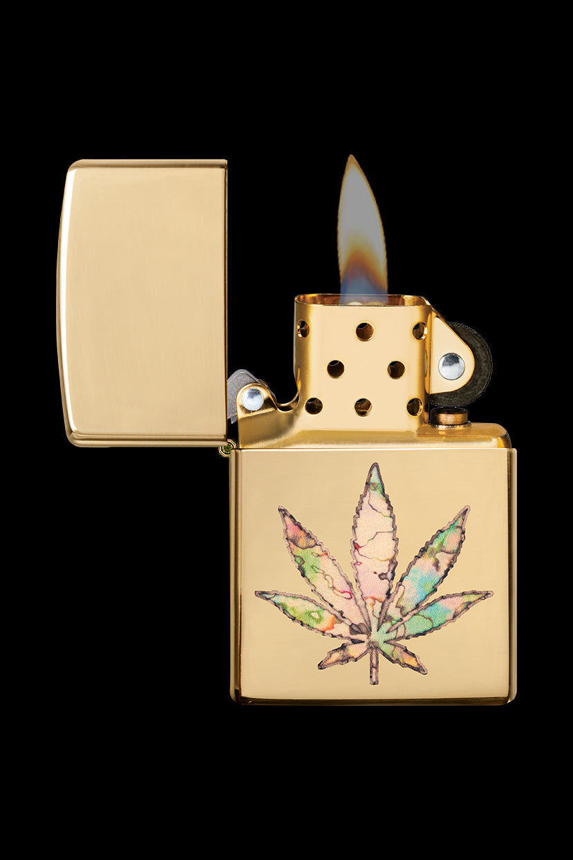 Gold Zippo lighter with a colorful cannabis leaf design, flame lit.