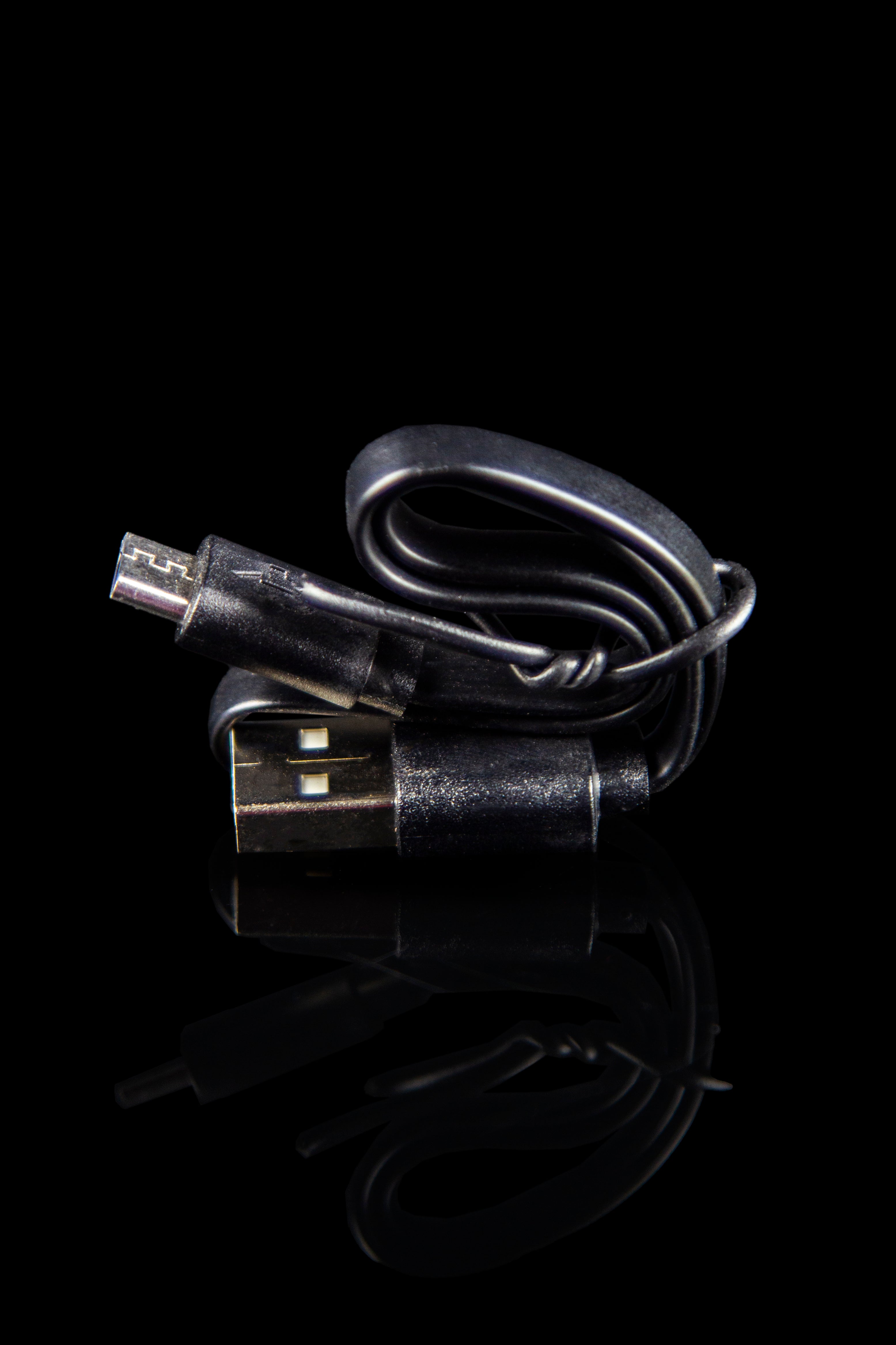 USB charger for a cannabis vape pen, isolated on black.