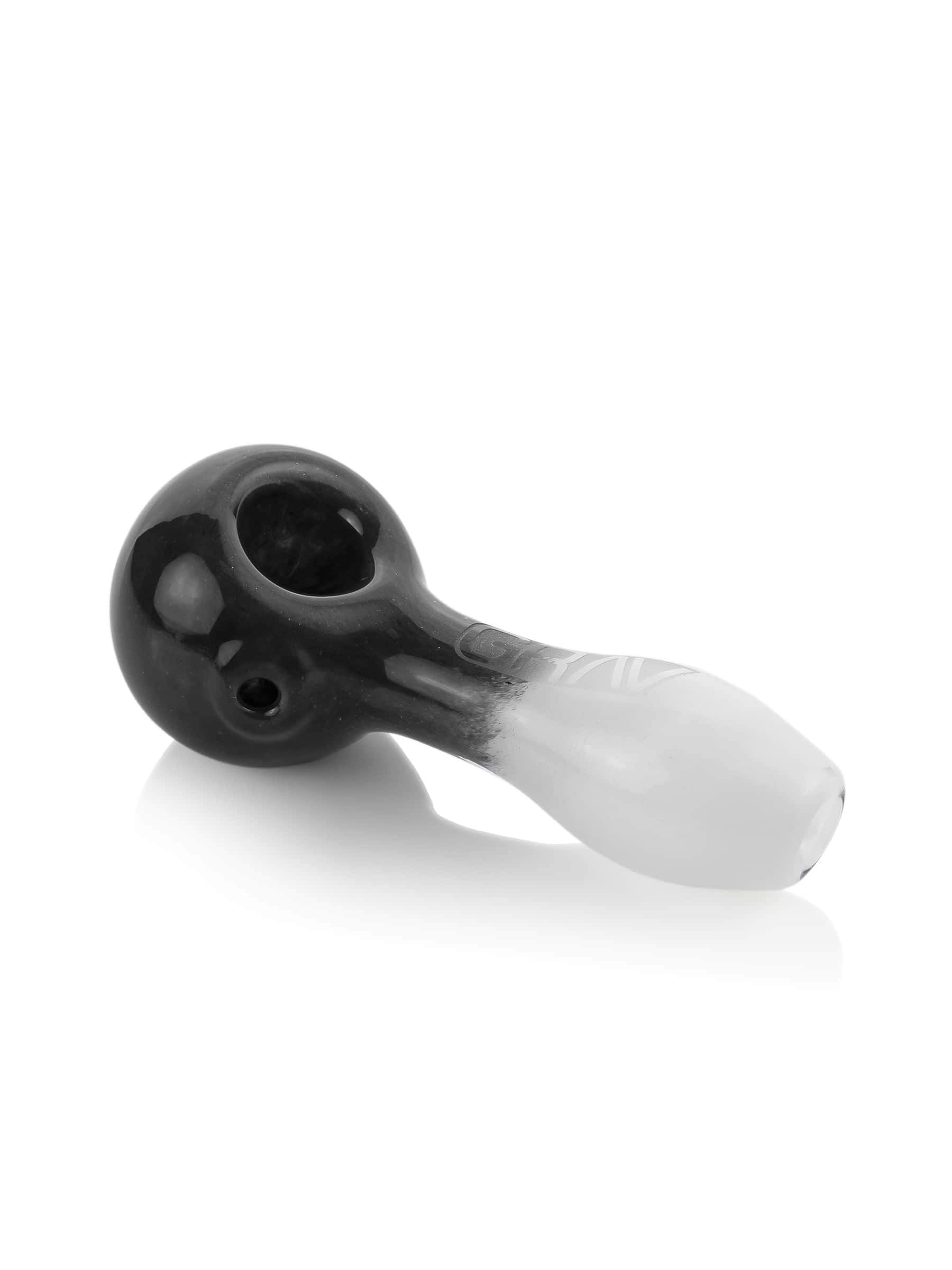 A close-up, angled view of the GRAV® Frit Spoon, showcasing its smooth, dark glass construction.