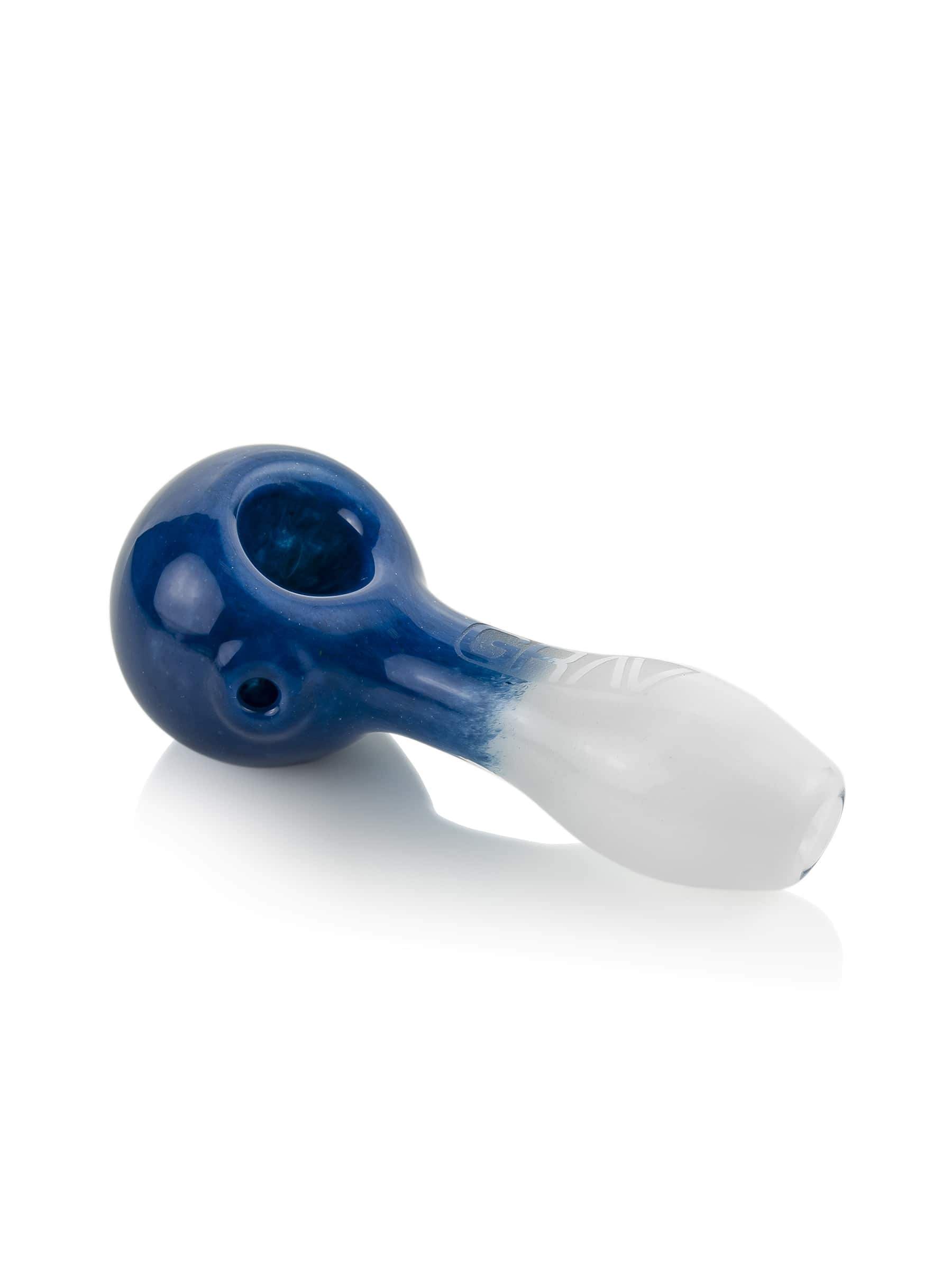 A close-up, angled view of the GRAV® Frit Spoon, showcasing its smooth, blue glass construction and curved design.