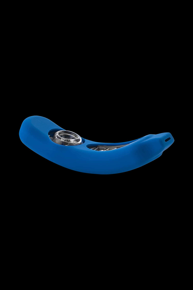 Angled close-up of a blue GRAV® Rocker Steamroller with Silicone Skin showing its curved silicone body and exposed metal bowl against a black background.