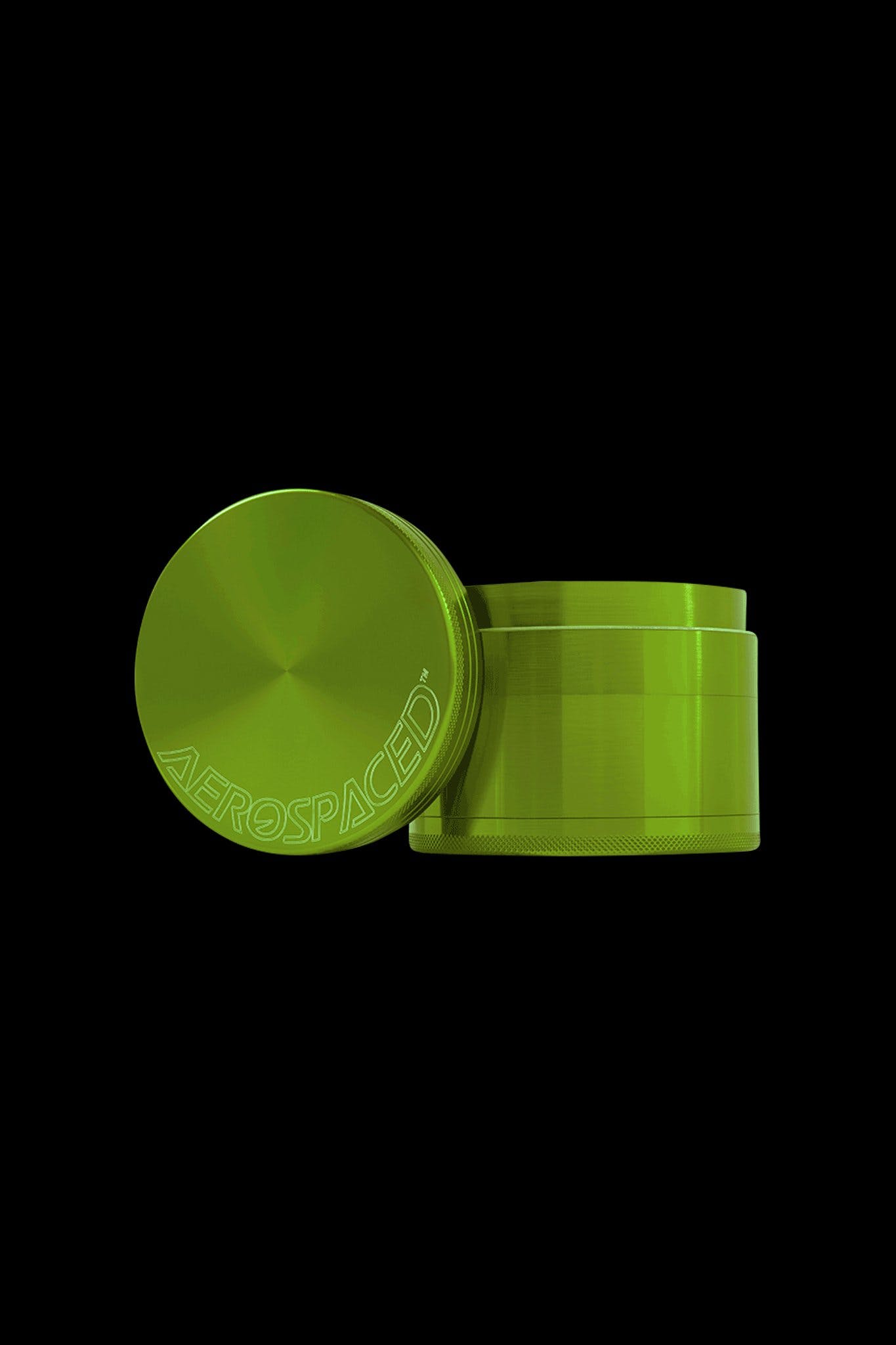 Green metal cannabis grinder with “AEROSPACE” etched on the lid, isolated on a black background.