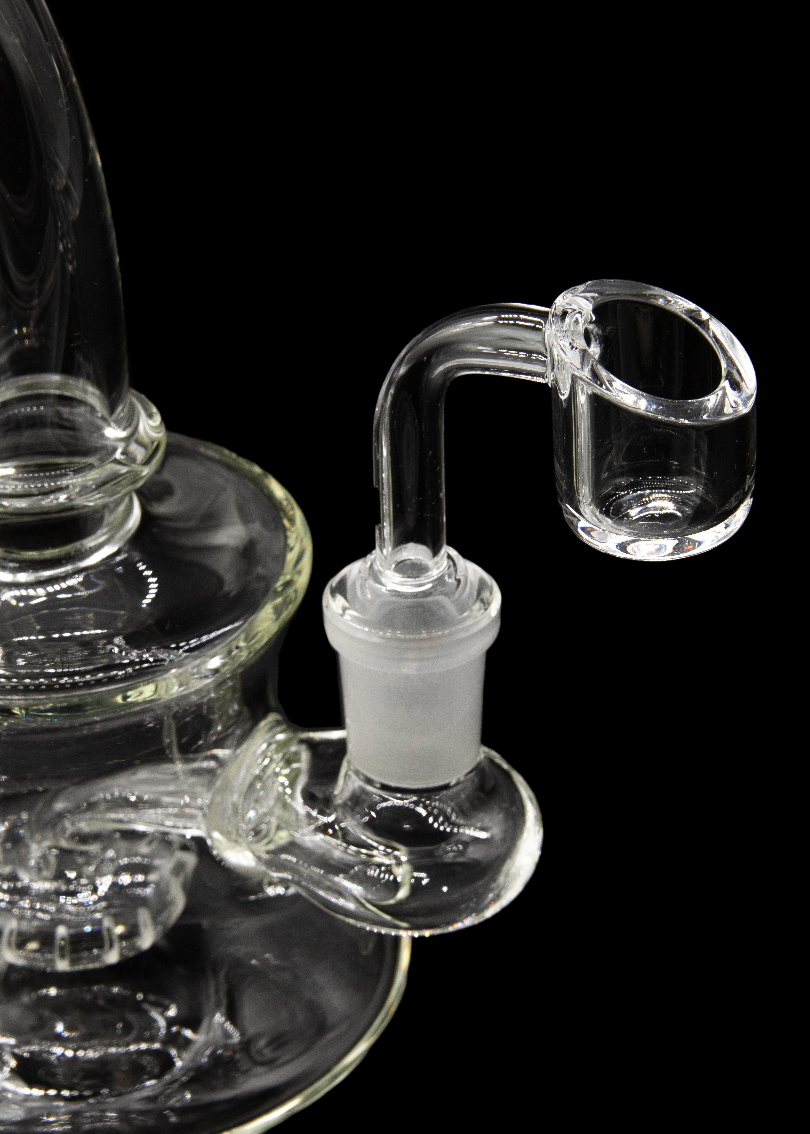 Clear glass dab rig with a quartz banger against a black background.