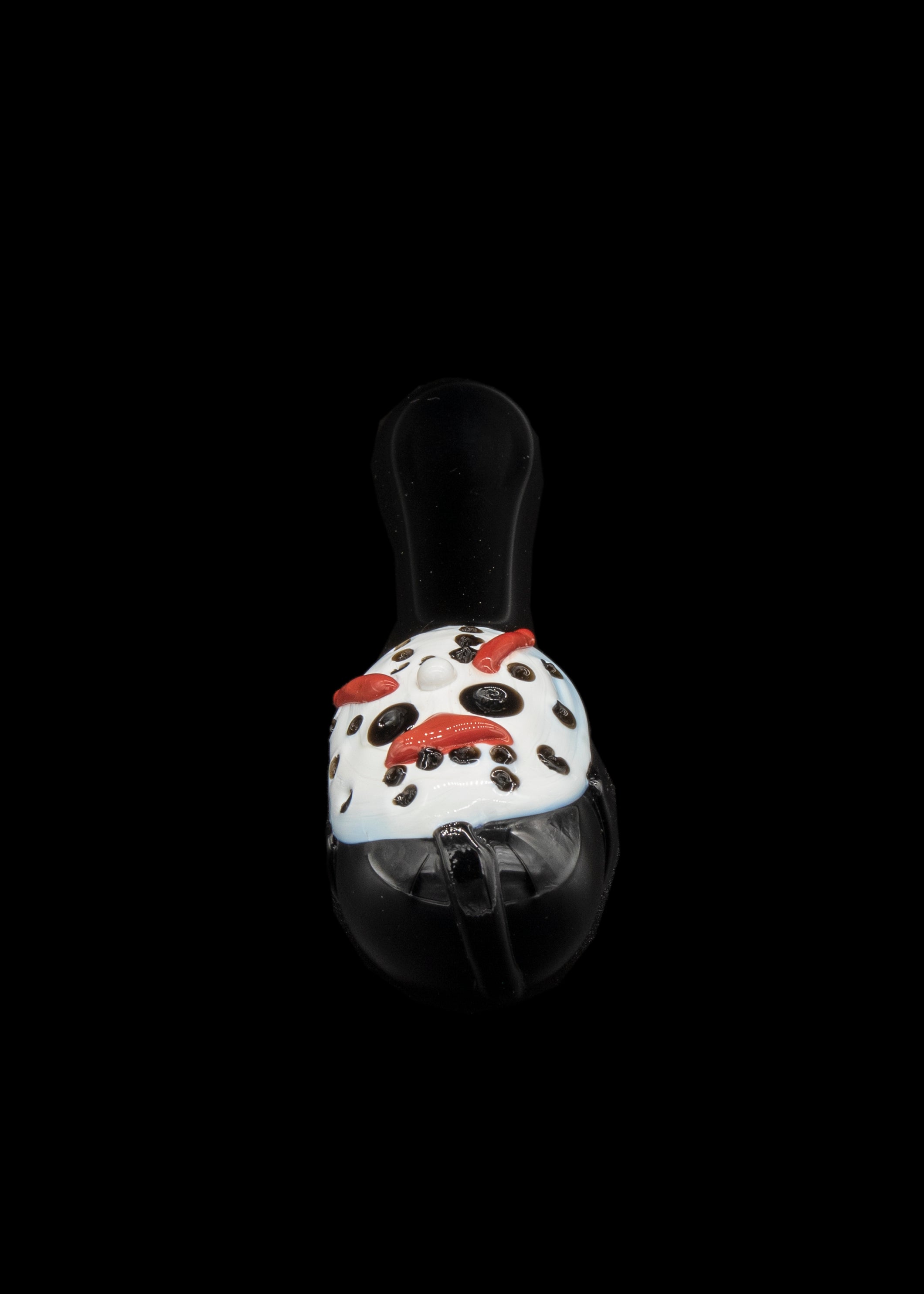 A mushroom-shaped glass pipe with a white speckled cap and red accents, against a black background.