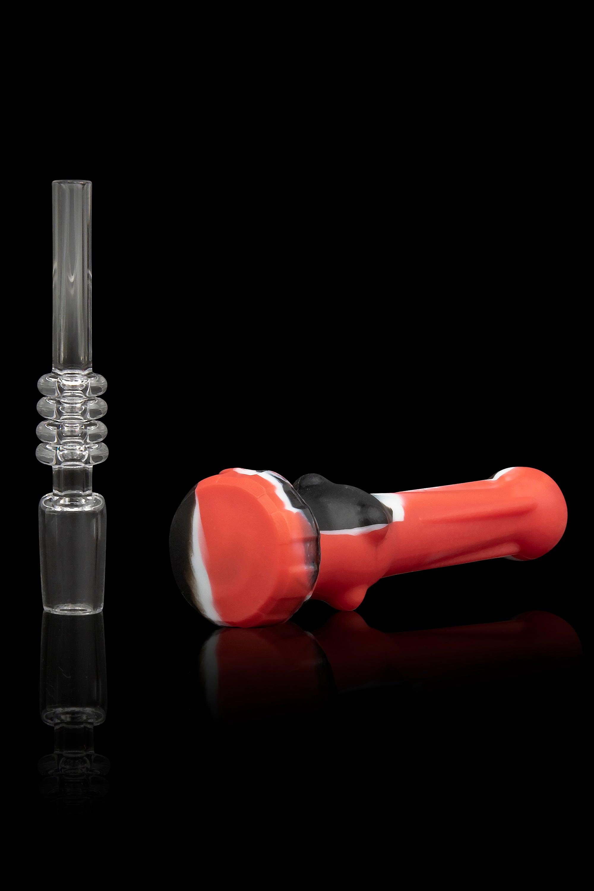 Red silicone dab rig with a clear glass downstem, reflecting on a glossy surface.