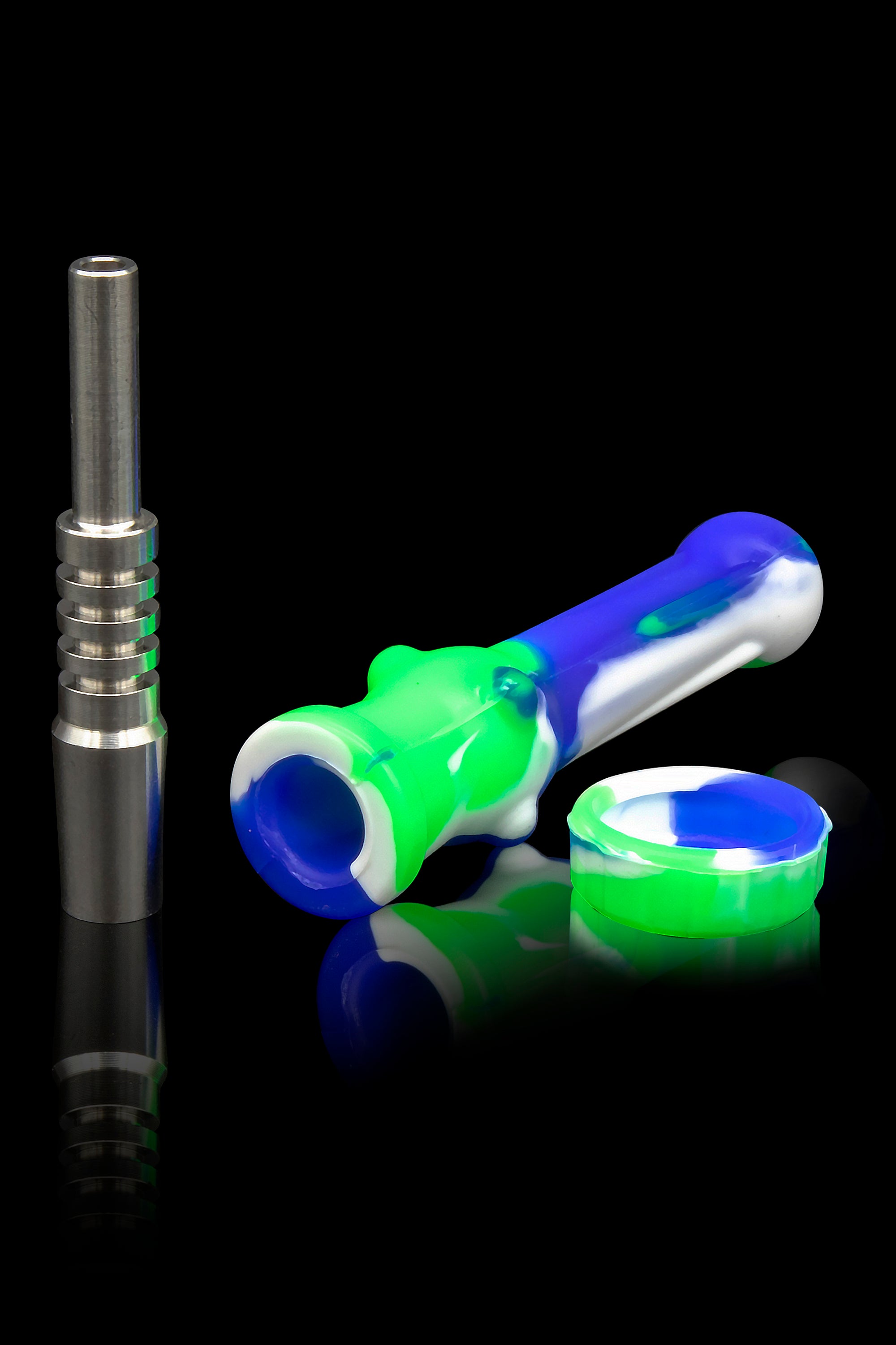 Dab rig components including a titanium nail, silicone dab tool, and silicone dish on a reflective surface.