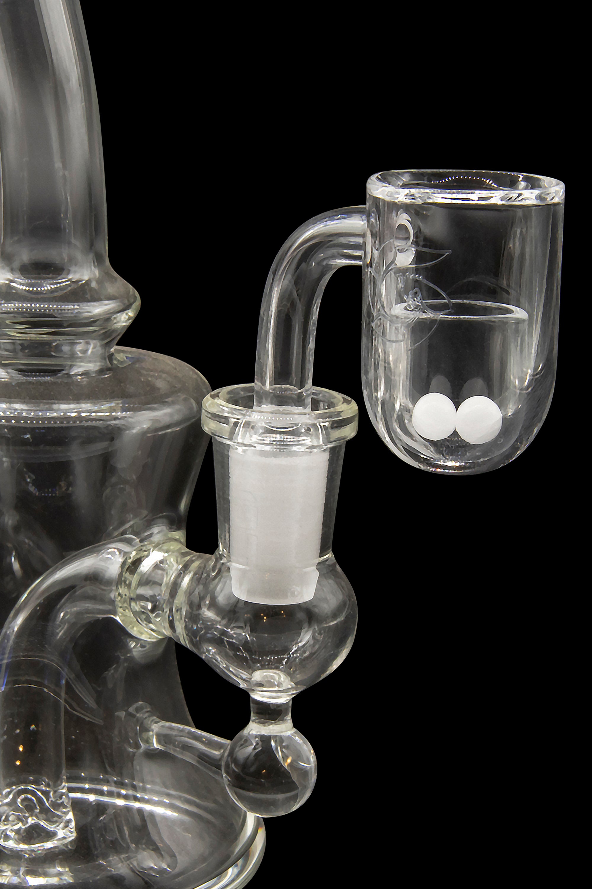 Clear glass water pipe (rig) with a quartz banger containing white cannabis concentrate (crumble or wax).