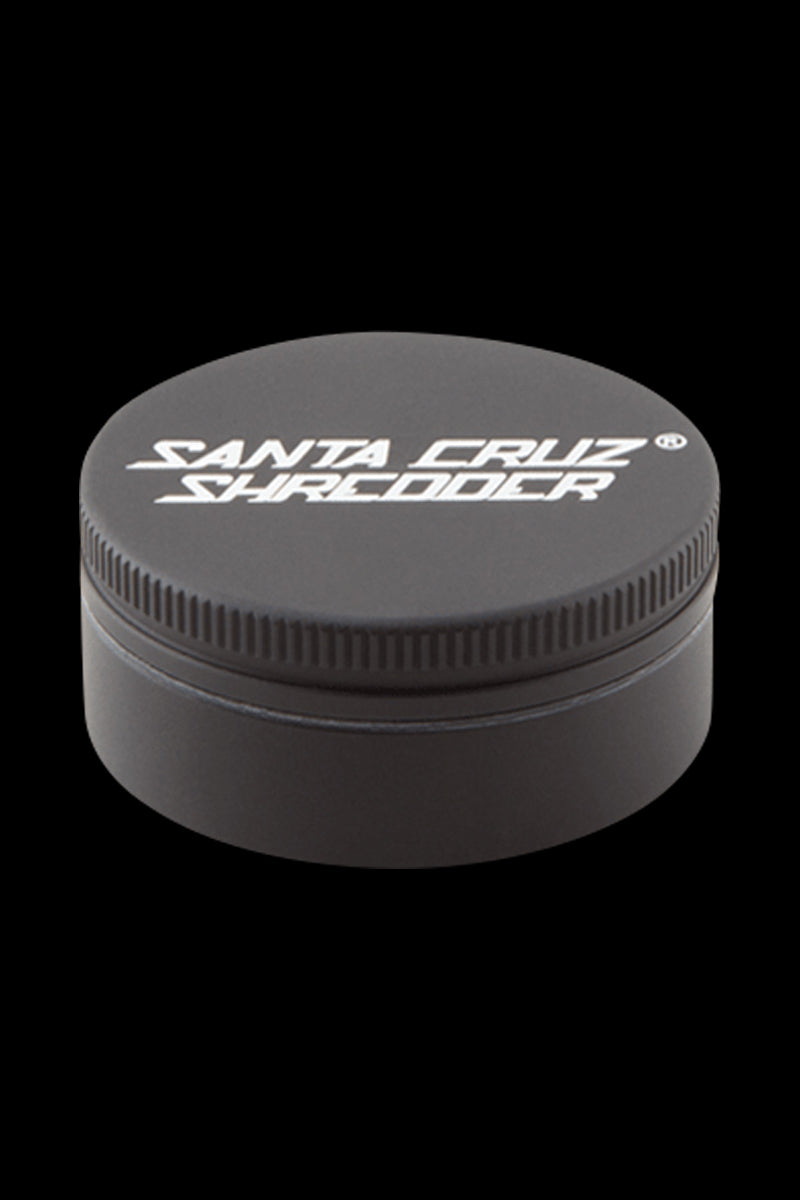 Top-front view of a small, orange Santa Cruz Shredder 2-Piece Grinder on a black background, showing the ribbed lid and white logo.