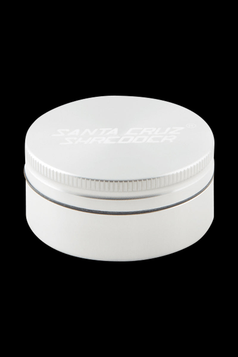 Top-down view of a small gray Santa Cruz Shredder 2-Piece Grinder centered on a black background, showing its ridged lid and subtle embossed logo.