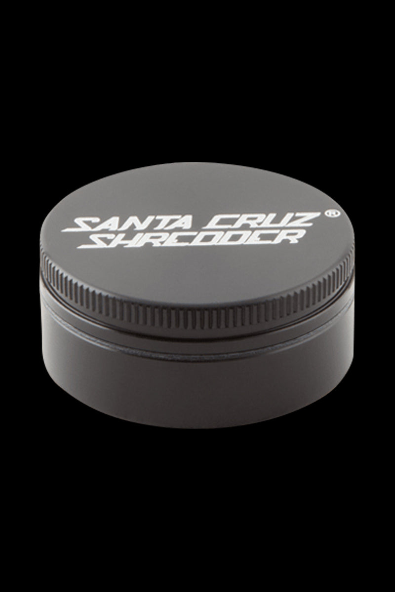 Close-up front view of a small blue Santa Cruz Shredder 2-Piece Grinder centered on a black background showing the textured lid edge and white logo.