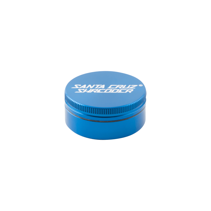 Top-down view of a blue Santa Cruz Shredder 2-Piece Grinder with white logo on the lid and subtle shadow on a white background