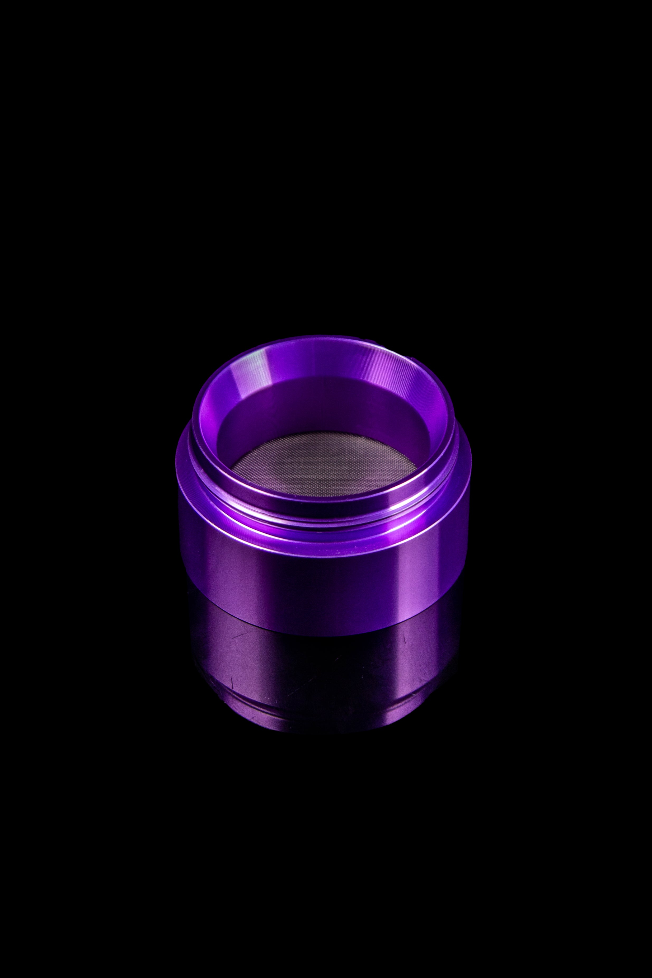 Purple cannabis grinder sieve or screen on black background.