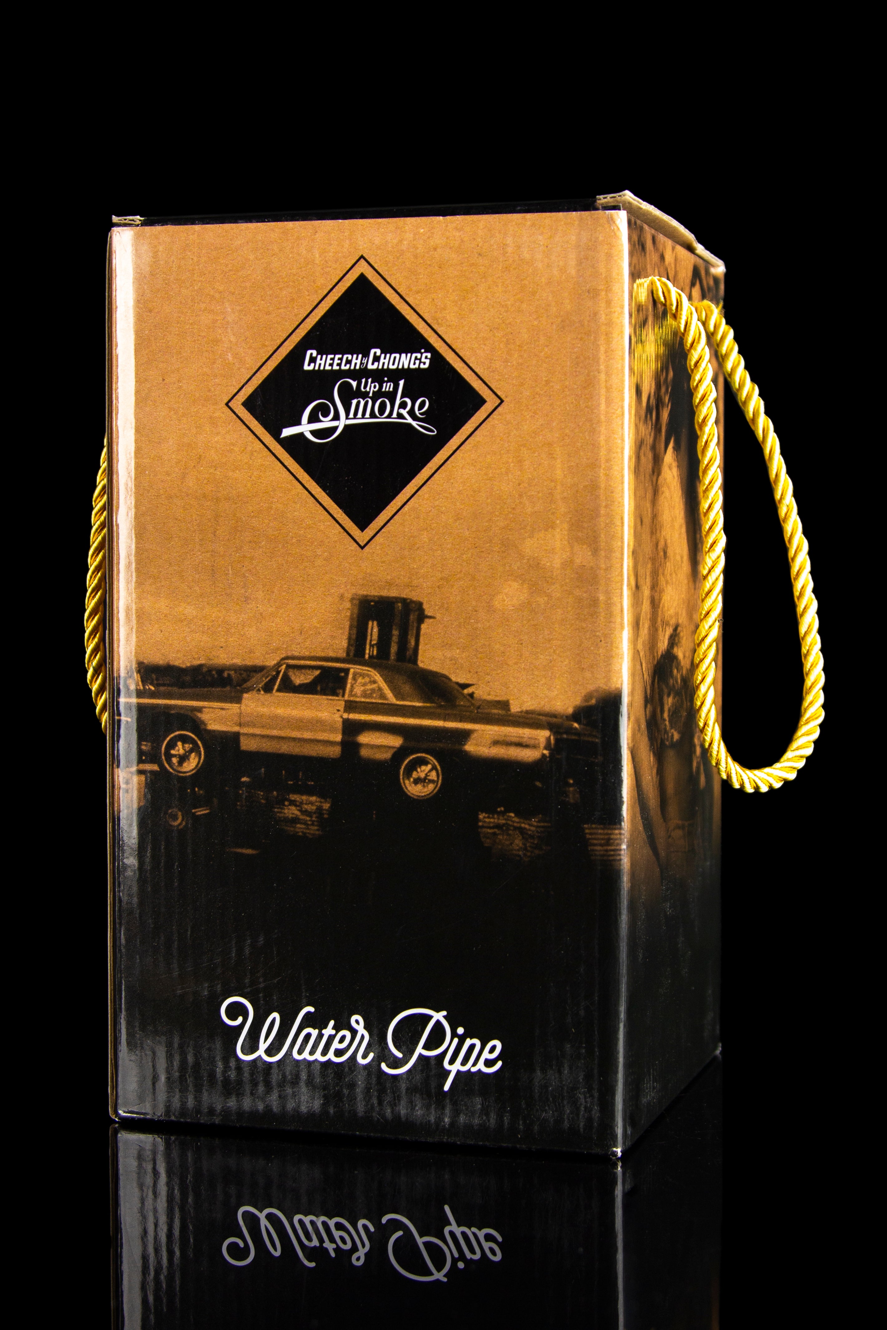 Brown cardboard box for "Cheech & Chong's Up in Smoke" water pipe, featuring a vintage car illustration and rope handle.