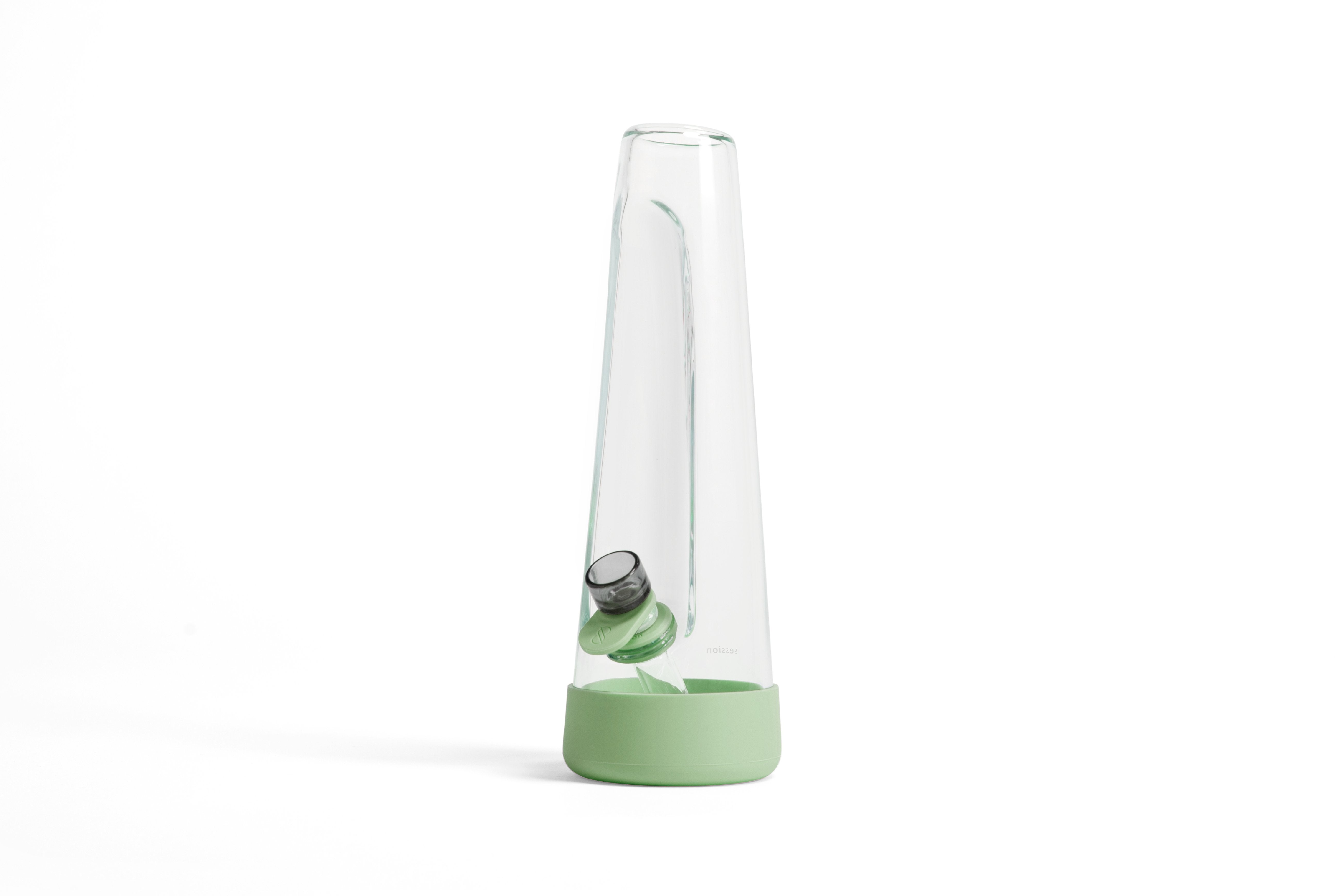 Angled close-up of the clear glass Session Goods Modern Bong with a green silicone base and downstem against a white background