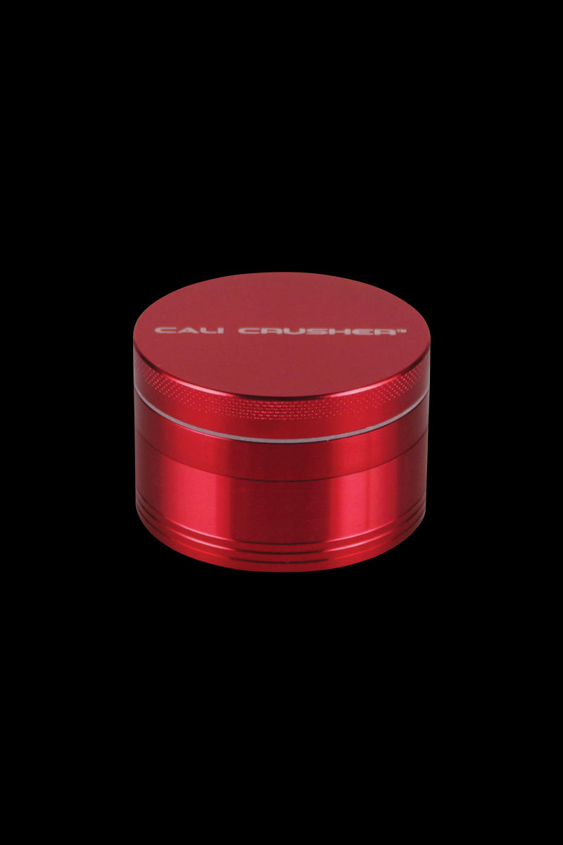 A close-up of the red Cali Crusher O.G. 2.5" 4 Piece Grinder, viewed from a slight upward angle.