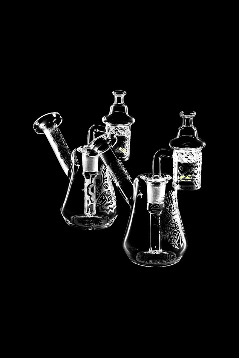 A slightly angled studio shot of the Compact Travel Etched Dab Rig Set, showcasing its detailed etching and compact size against a dark backdrop.