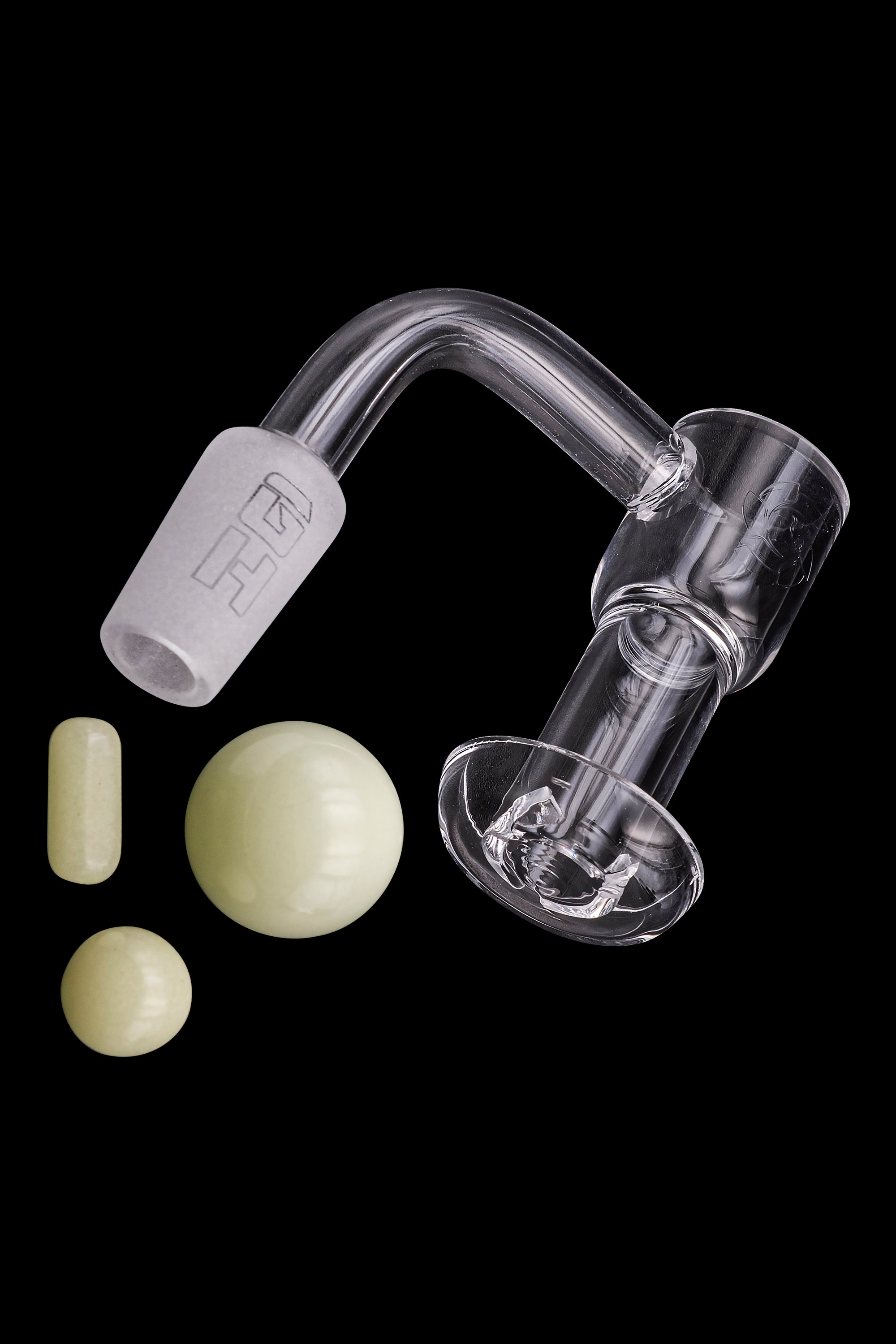 Quartz dab rig components including a banger, carb cap, and terp pearls on a black background.