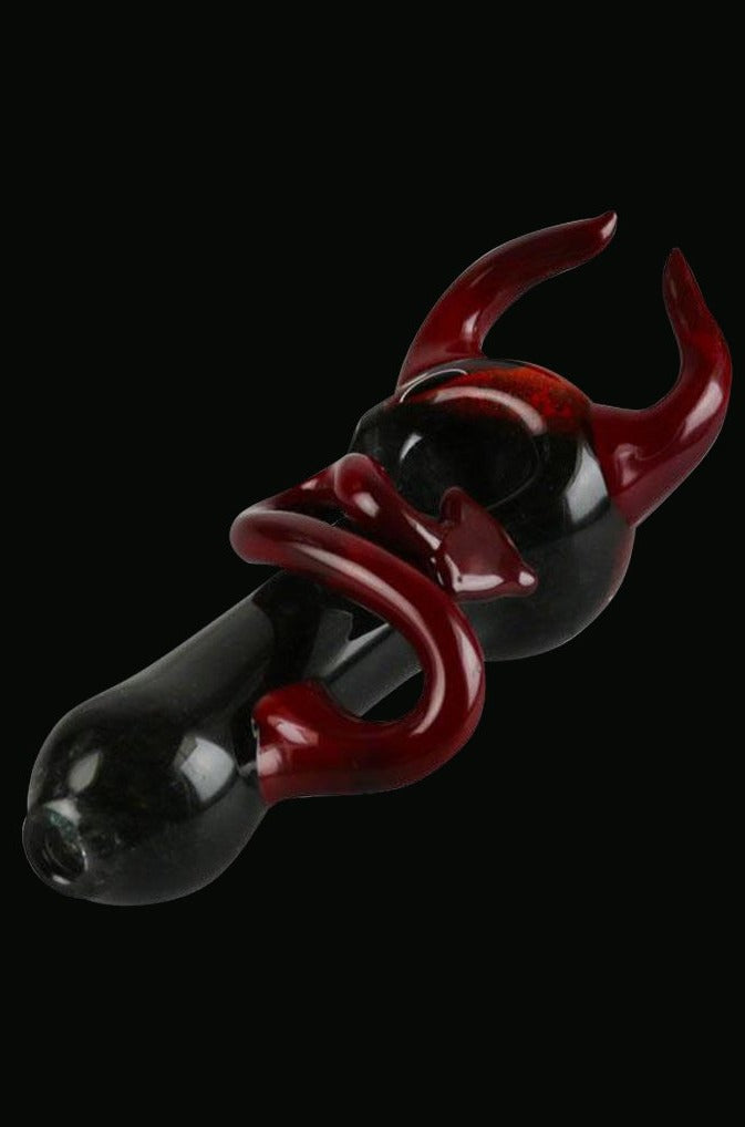 A side view of the Devil Horns and Tail Fritted Spoon Pipe, showcasing its detailed glasswork and unique sculpted design.