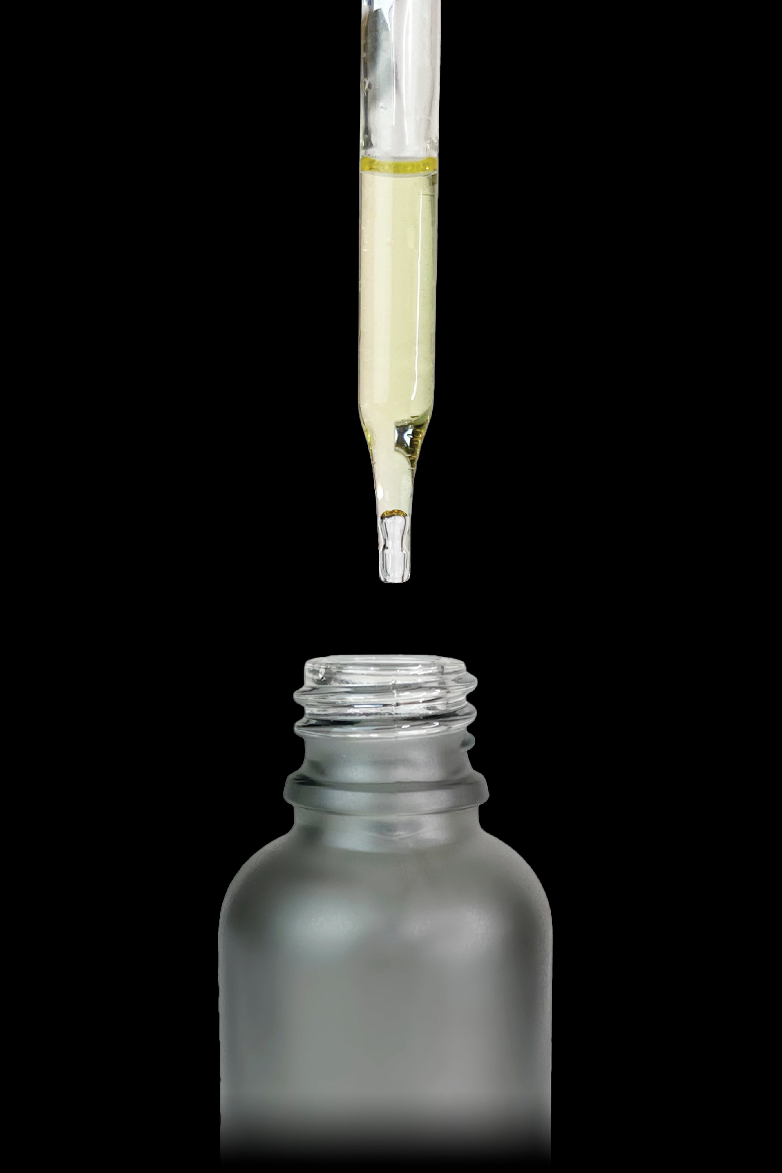 Cannabis oil dropper dispensing liquid into a glass bottle.