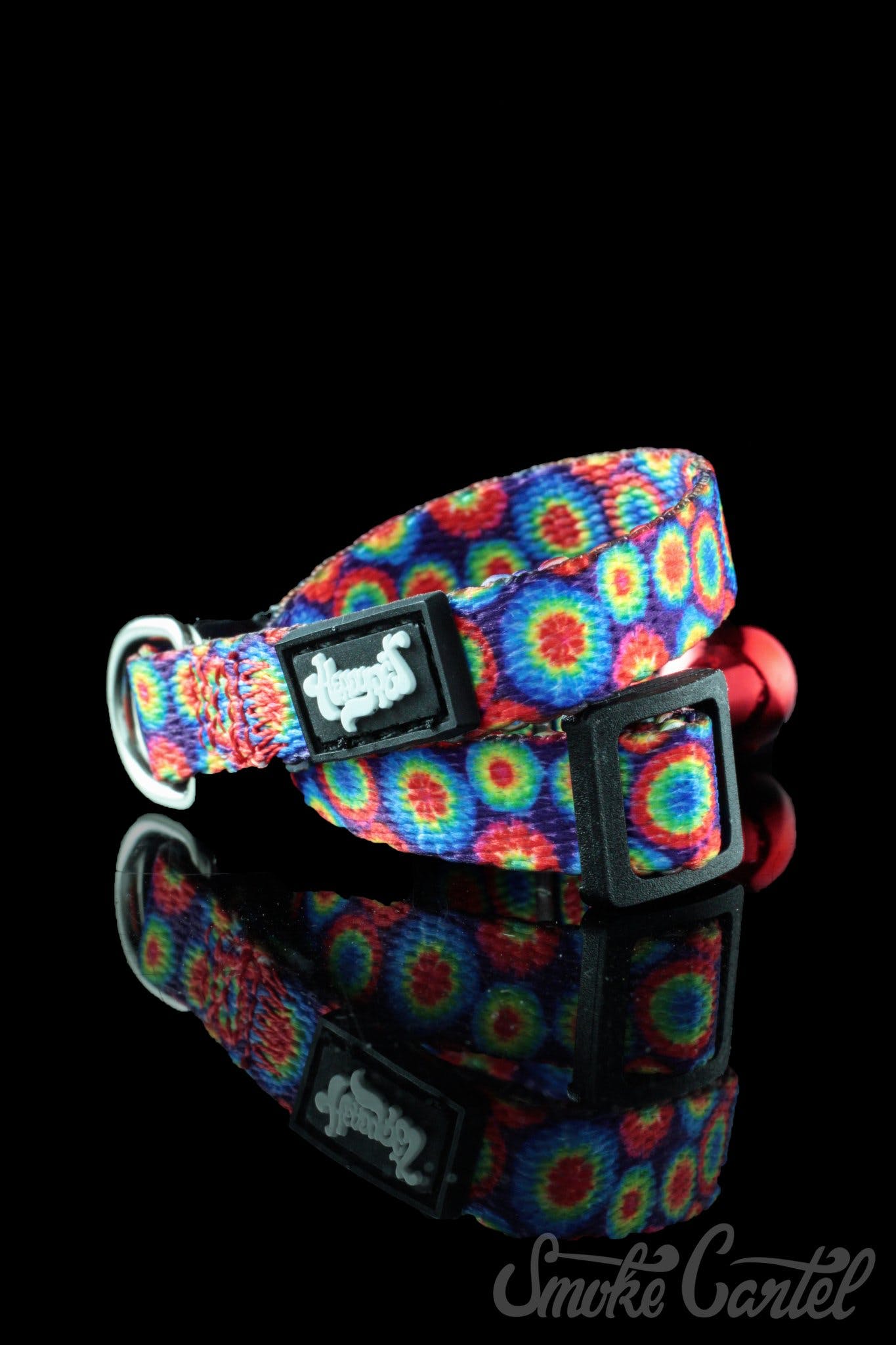 A close-up view of the HeadyPet Cat Collar, showcasing its colorful, patterned design against a dark, reflective surface.