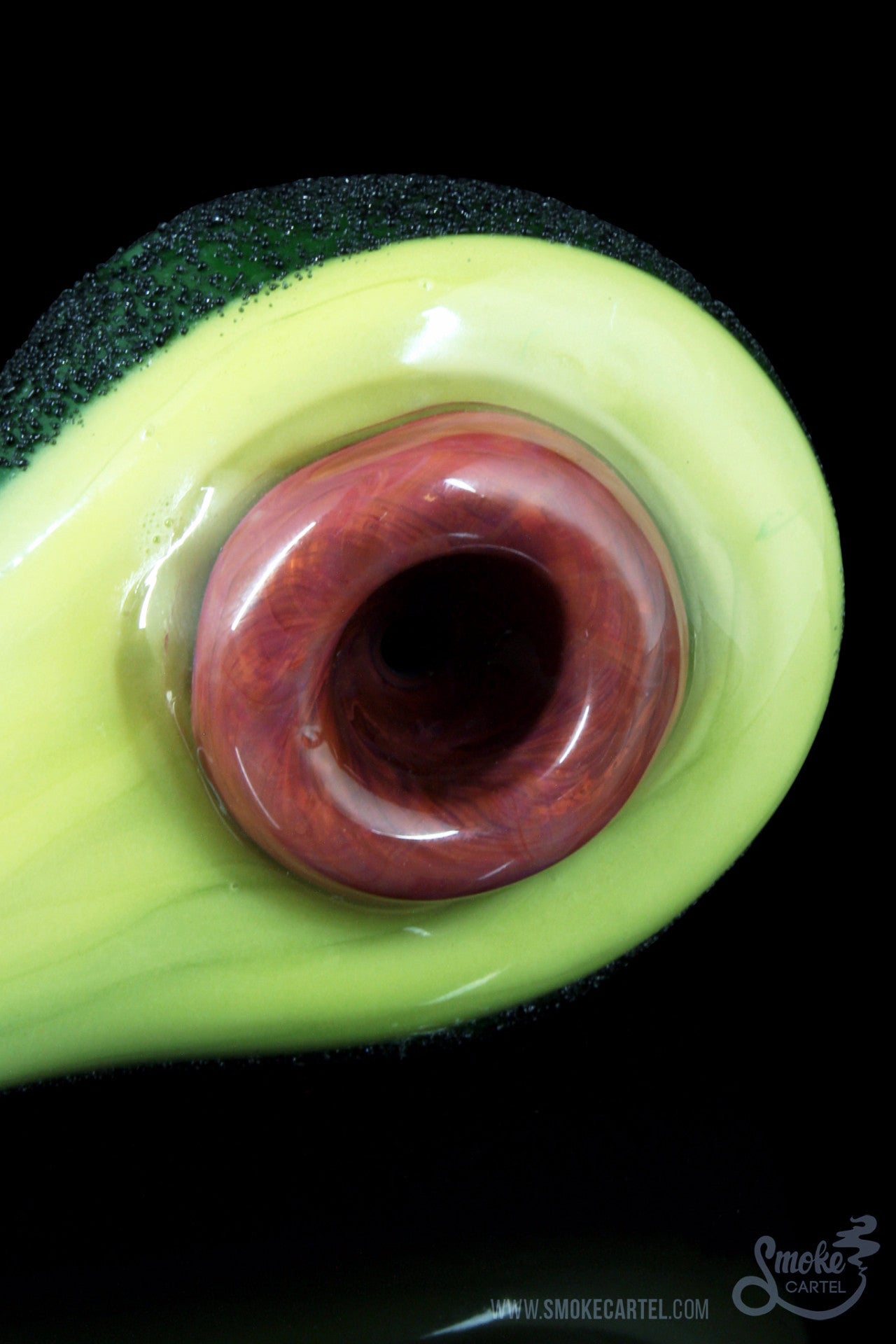 Close-up view of the “Empire Glassworks Avocadope” hand pipe, resembling half an avocado with a visible bowl opening.