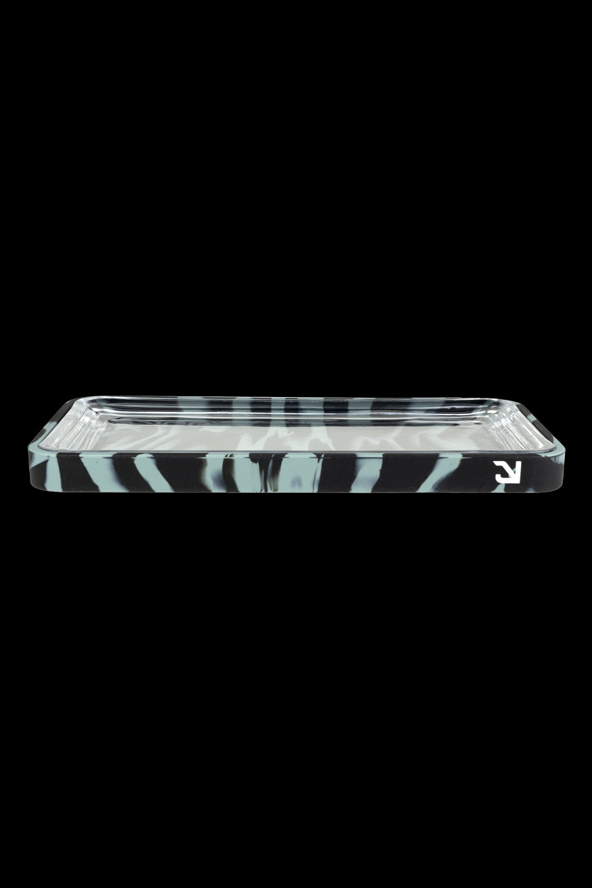 Clear glass rolling tray with white marbling against a black background.