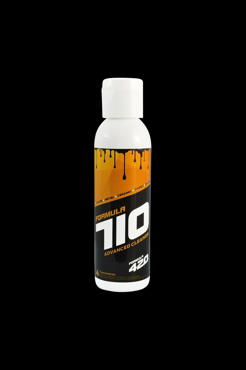 Centered front view of a travel-size Formula 710 Advanced Glass/Metal/Ceramic Cleaner bottle with orange-black label on black background