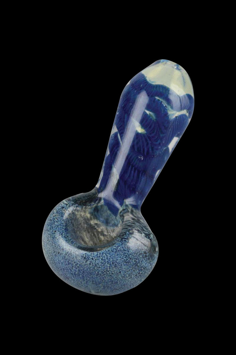 Angled close-up of a blue, frit-and-cord pattern Smoke Cartel Frit & Cord Worked Spoon Hand Pipe against a black background.