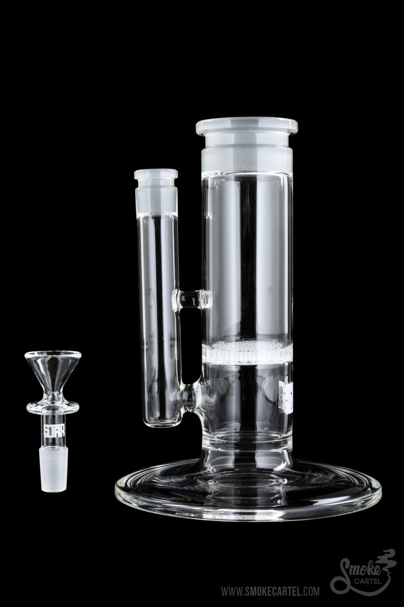 Clear glass bubbler water pipe with a glass bowl next to it on a black background.