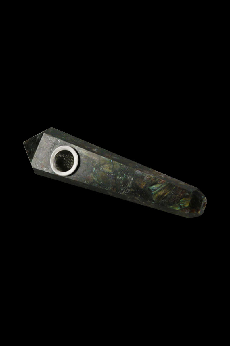 Angled close-up of a dark, faceted Natural Gemstone Mineral Hand Pipe with a circular metal bowl inset, shown against a black background