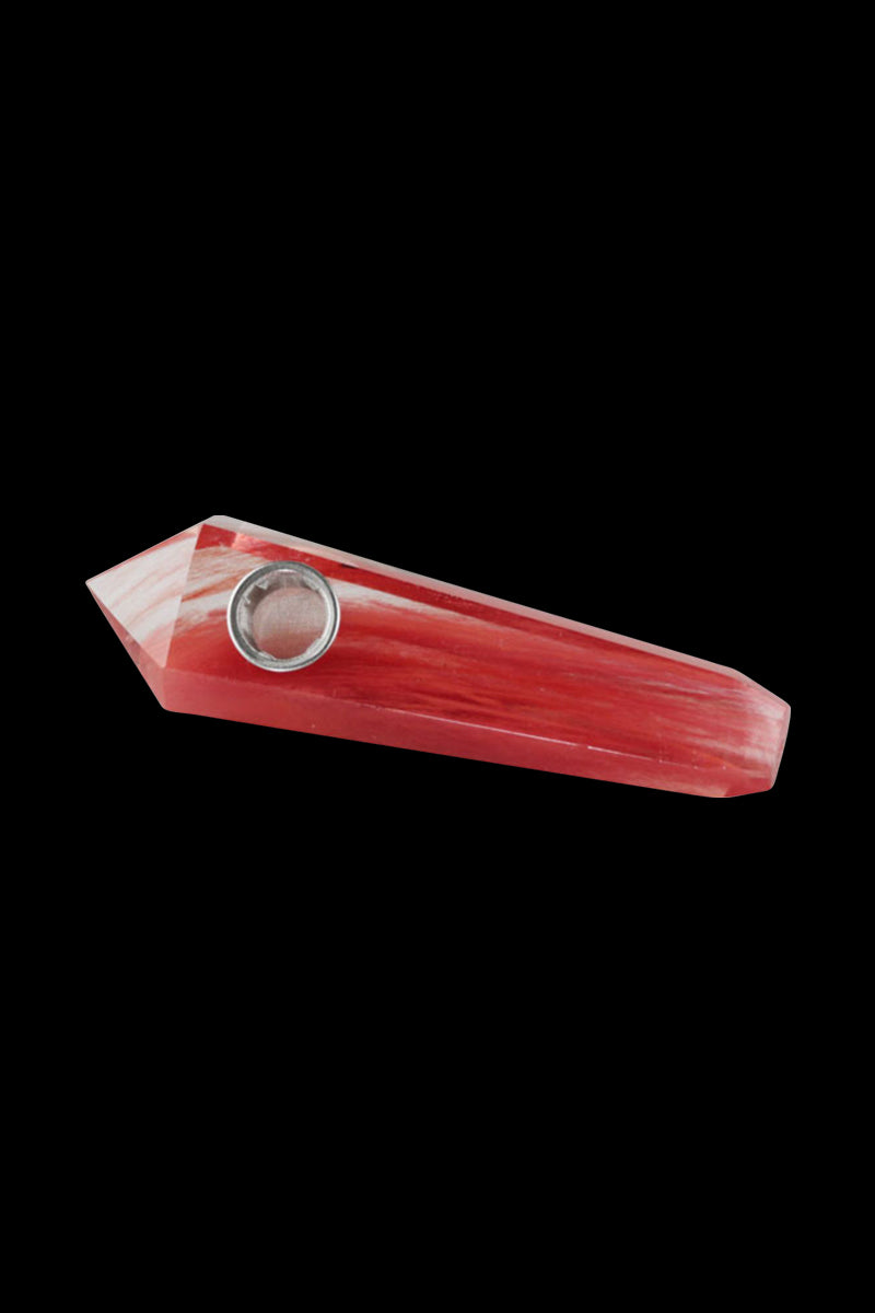 Angled close-up of a red Natural Gemstone Mineral Hand Pipe, shown against a black background highlighting its faceted point and metal bowl.