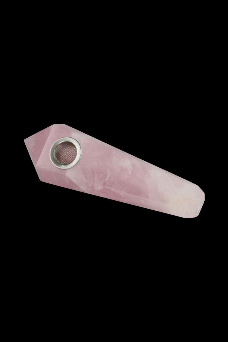 Angled top-down view of the Natural Gemstone Mineral Hand Pipe in smoky quartz, a faceted pale pink stone pipe with a metal bowl set against a black background.